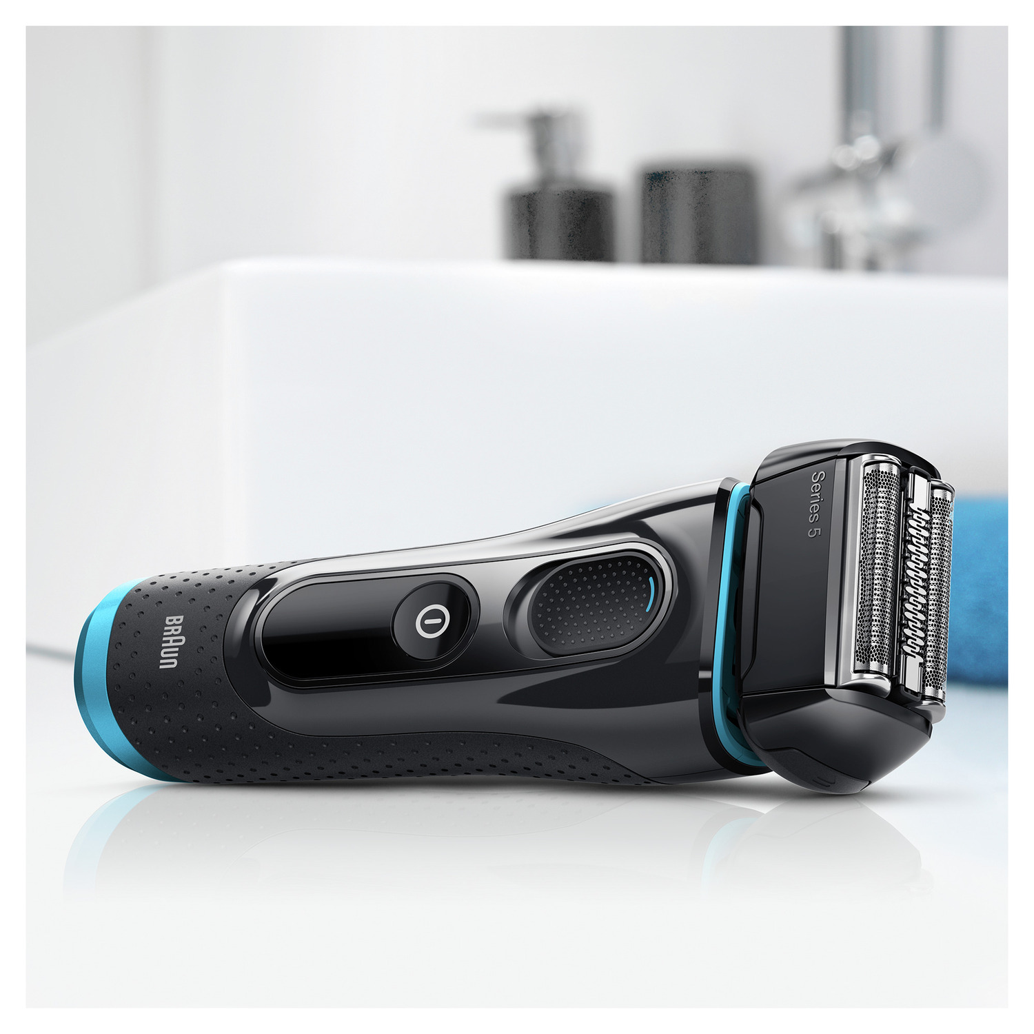 A black and blue Braun Series 5 shaver on a white surface, near a white sink.
