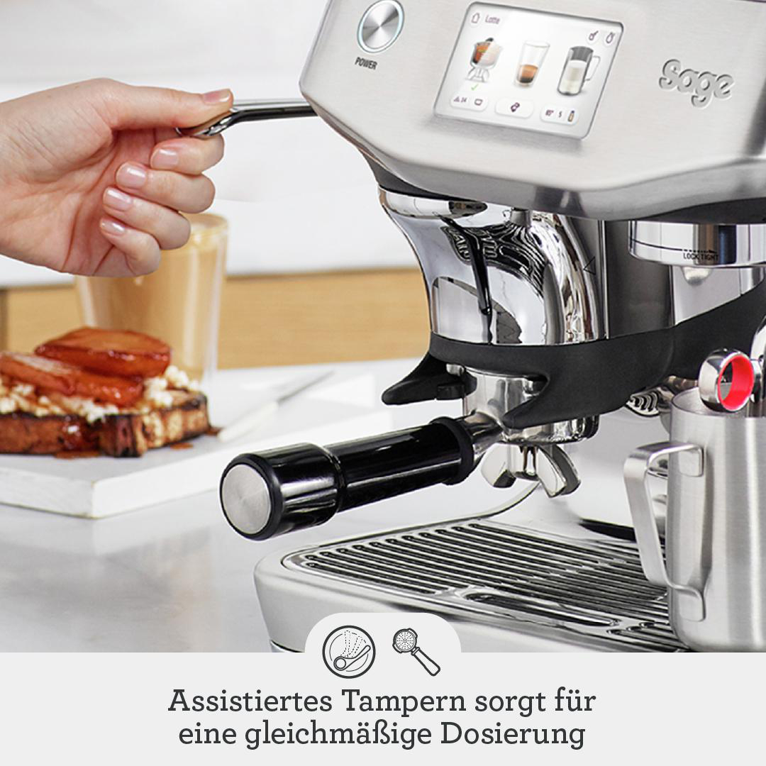 Hand bedient Kaffeemaschine mit Display, daneben Toast und Milchkanne.