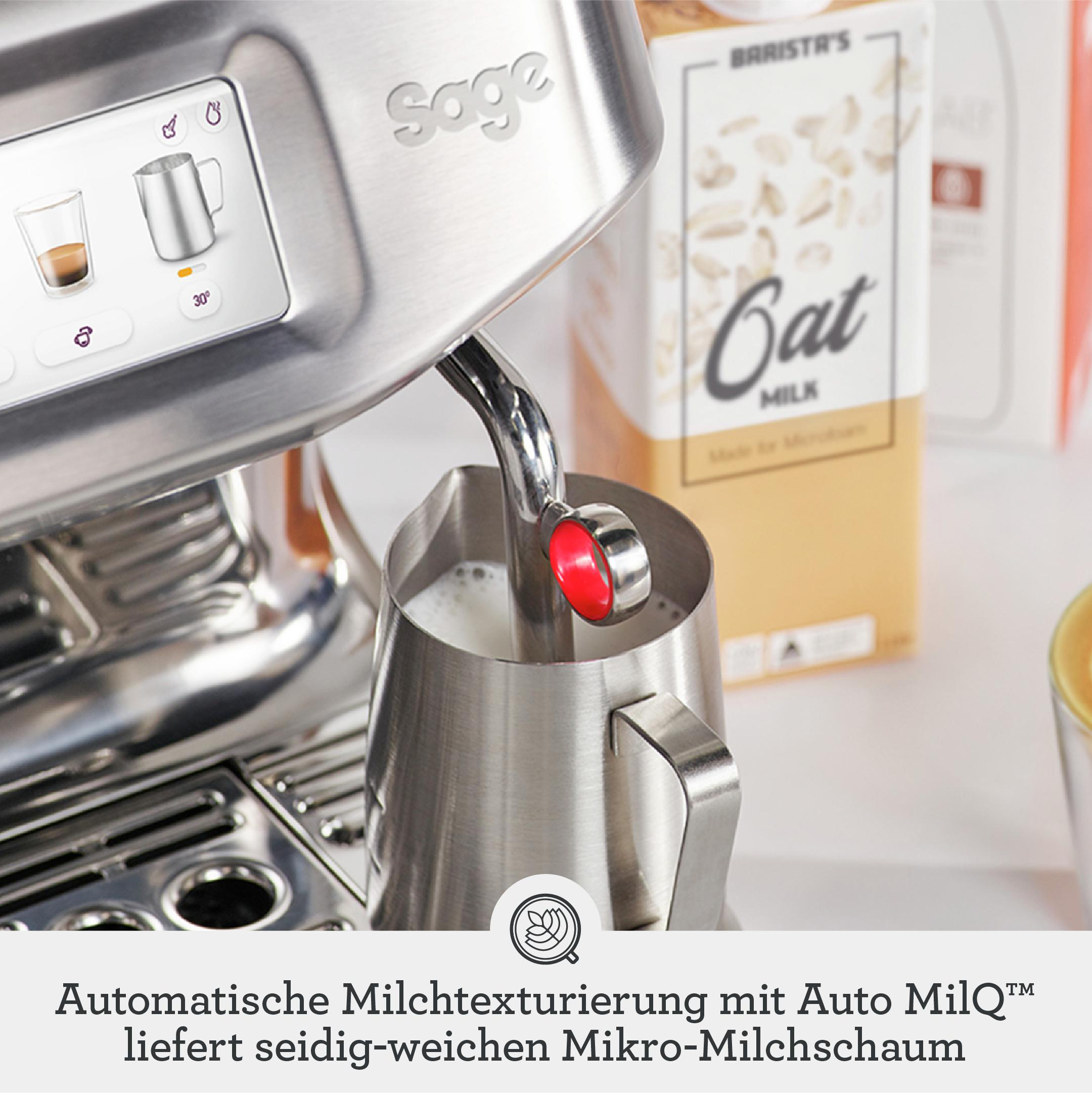 Edelstahl-Espressomaschine mit Dampfdüse in einem Milchgießkrug, dahinter Hafermilch.
