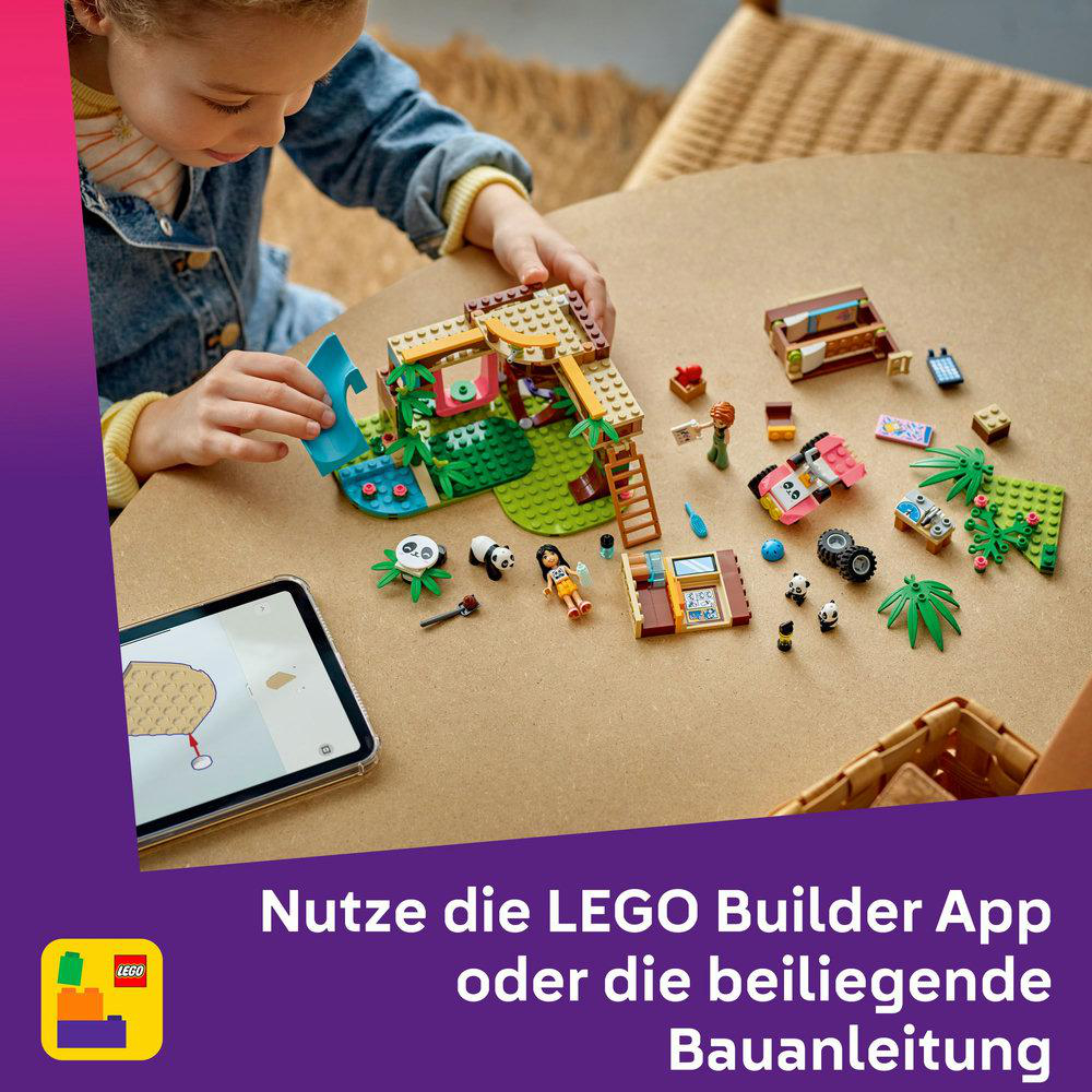 Kind spielt mit LEGO-Set, baut Panda-Schutzgebiet. Tablet auf dem Tisch.