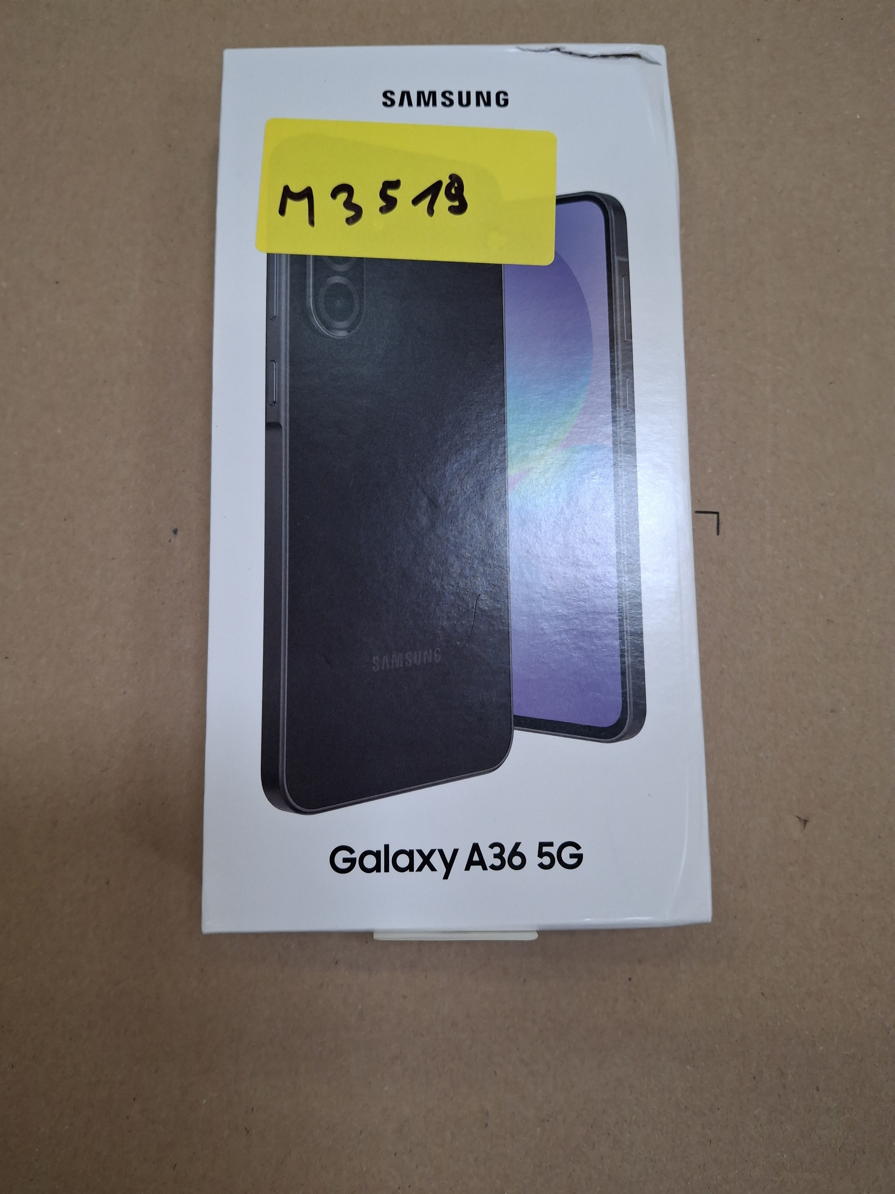 Pudełko Samsung Galaxy A36 5G z żółtą naklejką M3519 na brązowym tle.