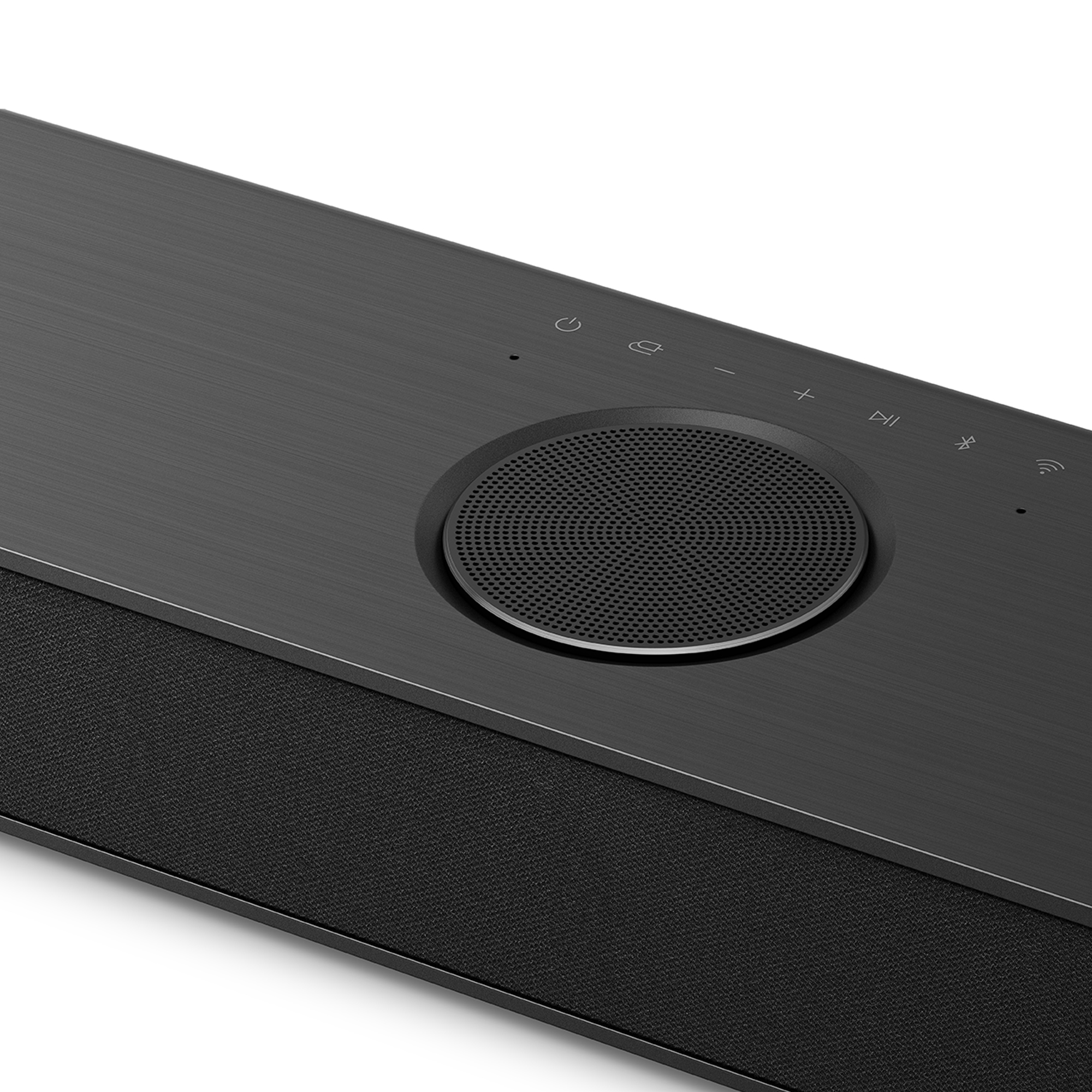 Primer plano de una barra de sonido. Tiene botones de control y un altavoz de malla en el centro.