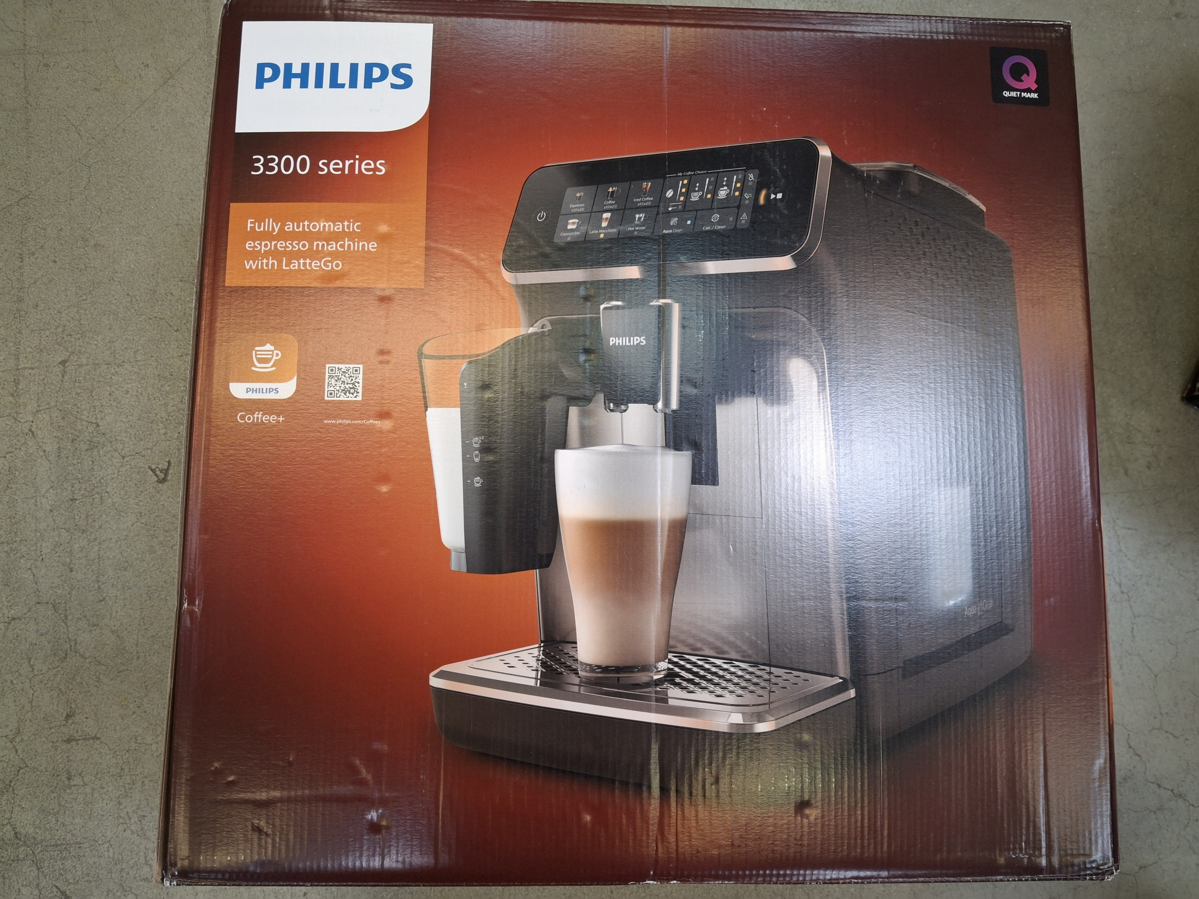Pudełko ekspresu do kawy Philips 3300, robiącego latte. Brązowe pudełko, czarna maszyna.