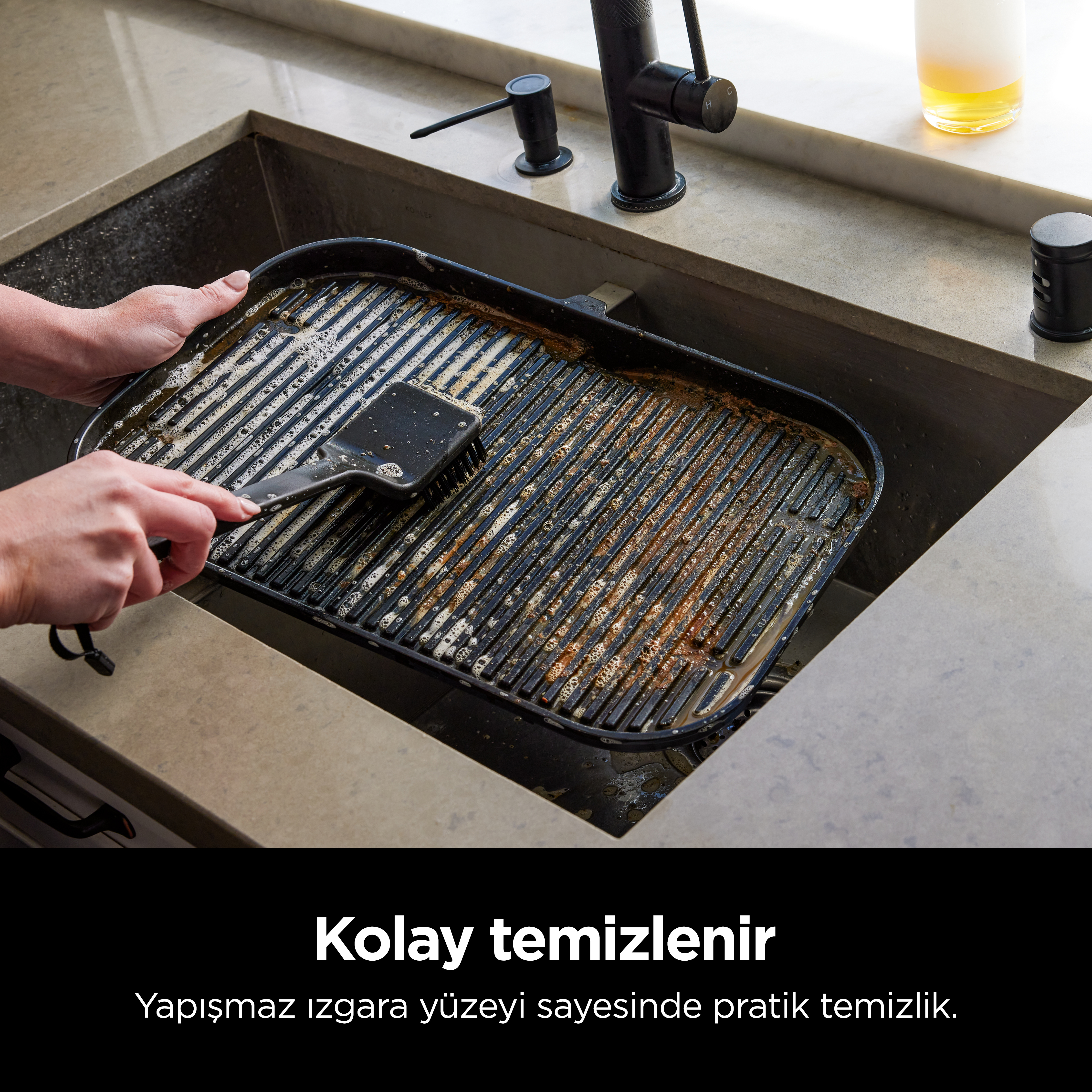 Bir kişi, lavaboda kirli bir ızgara tavasını temizliyor. Metin yerleşimi: Temizlemesi kolay.