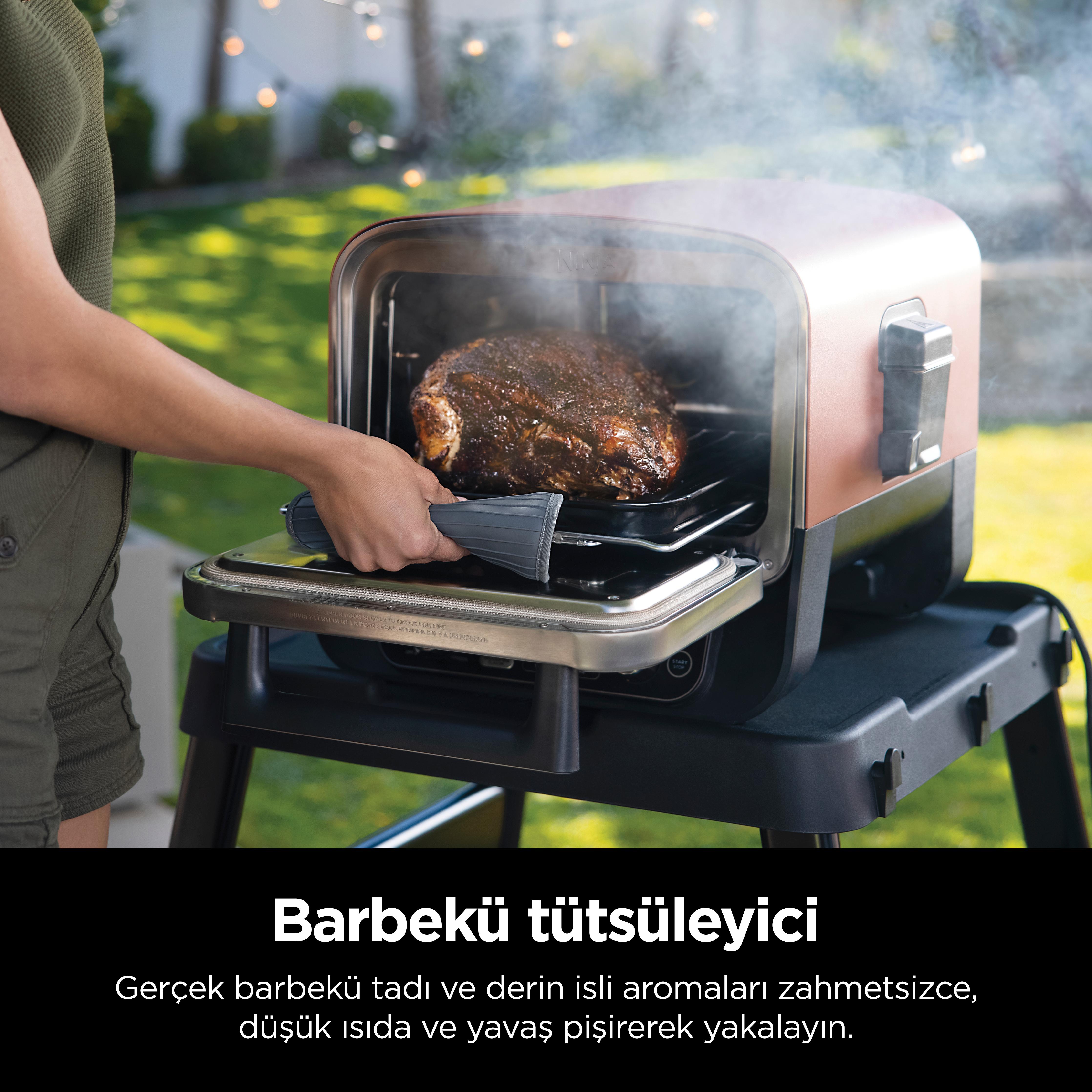 Bir kişi, ızgaradan bir rosto çıkarıyor. Metin: Barbekü tütsüleyici.