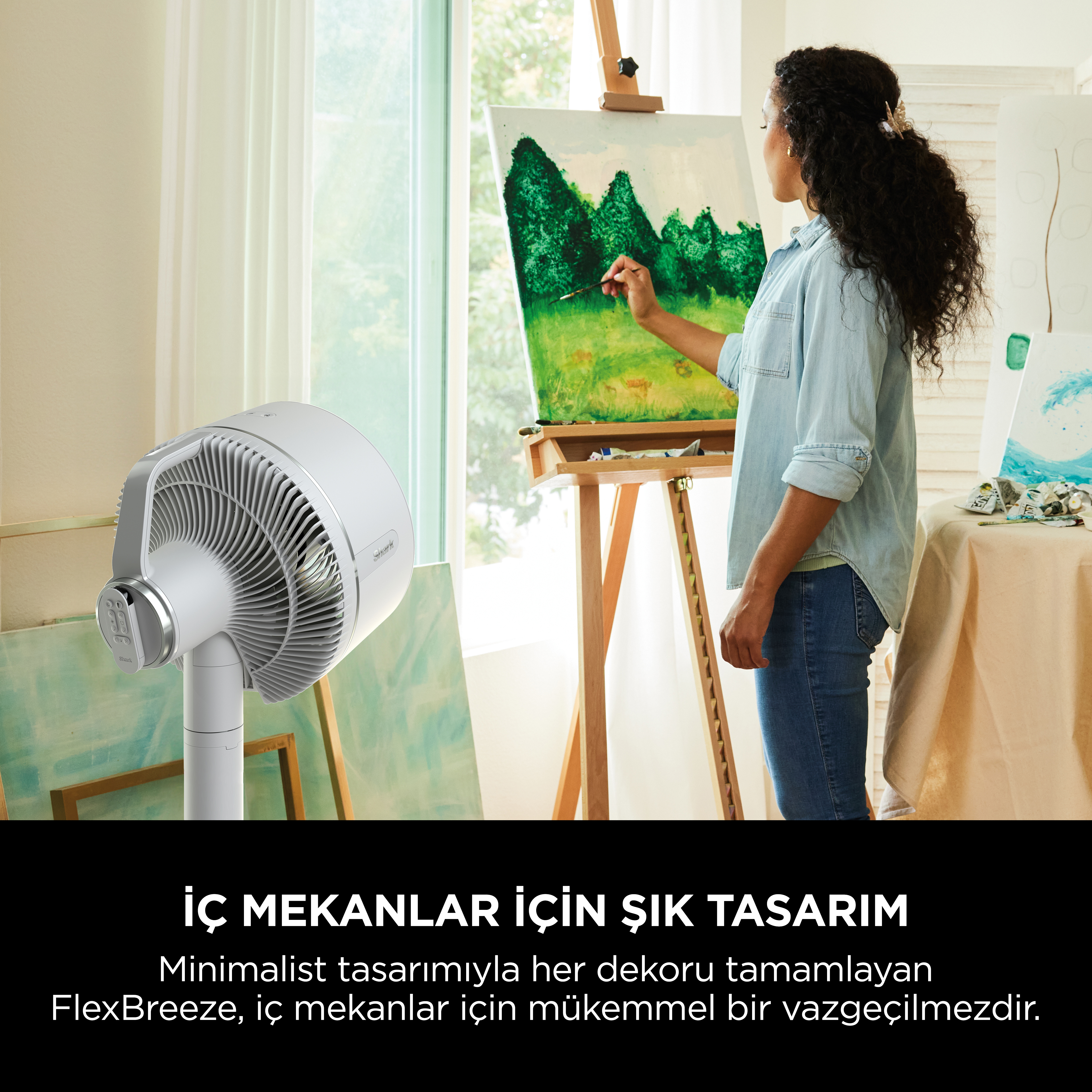 Beyaz bir vantilatörün önünde resim yapan bir kişi, duvarda sanat.