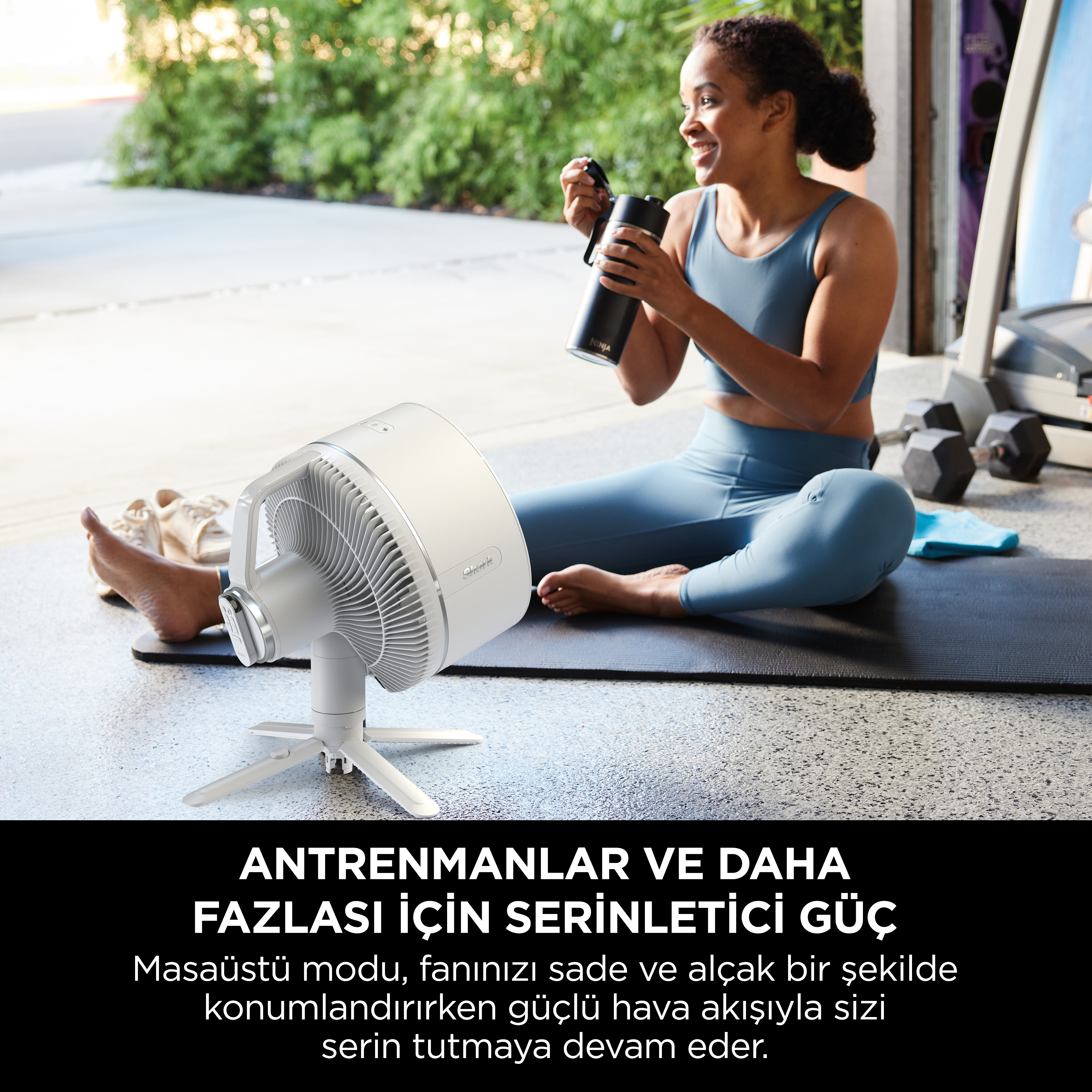 Beyaz bir vantilatör, bir şişe tutan bir kadın ve bir yoga matı.