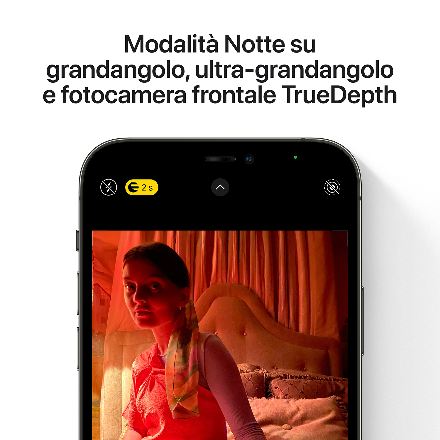 iPhone che mostra la modalità Notte. Una donna in abito rosso è nell'inquadratura. La stanza è buia.