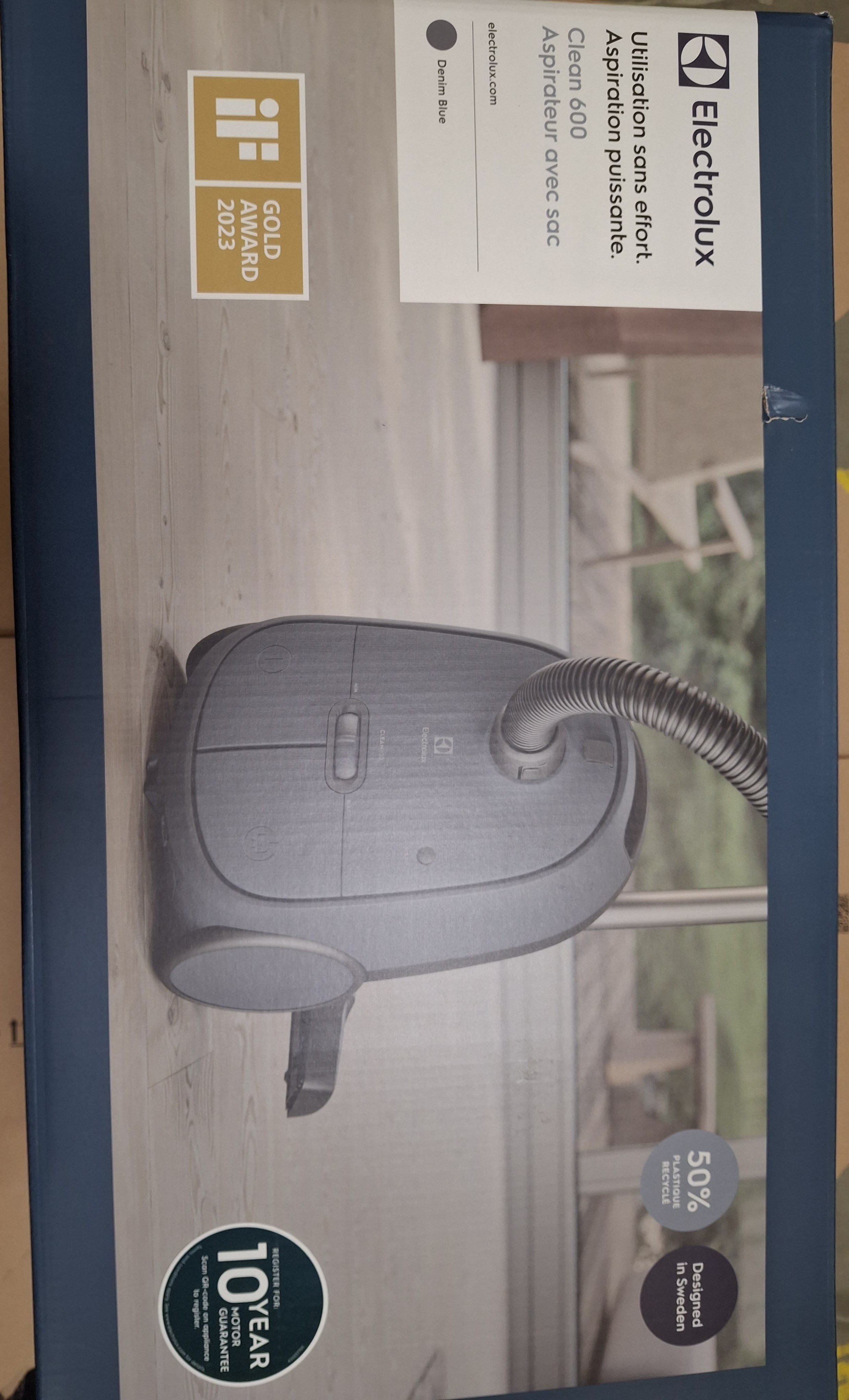 Pudełko odkurzacza Electrolux Clean 600. Obraz odkurzacza na pudełku. Tekst mówi 'Denim Blue' i 'Clean 600'.