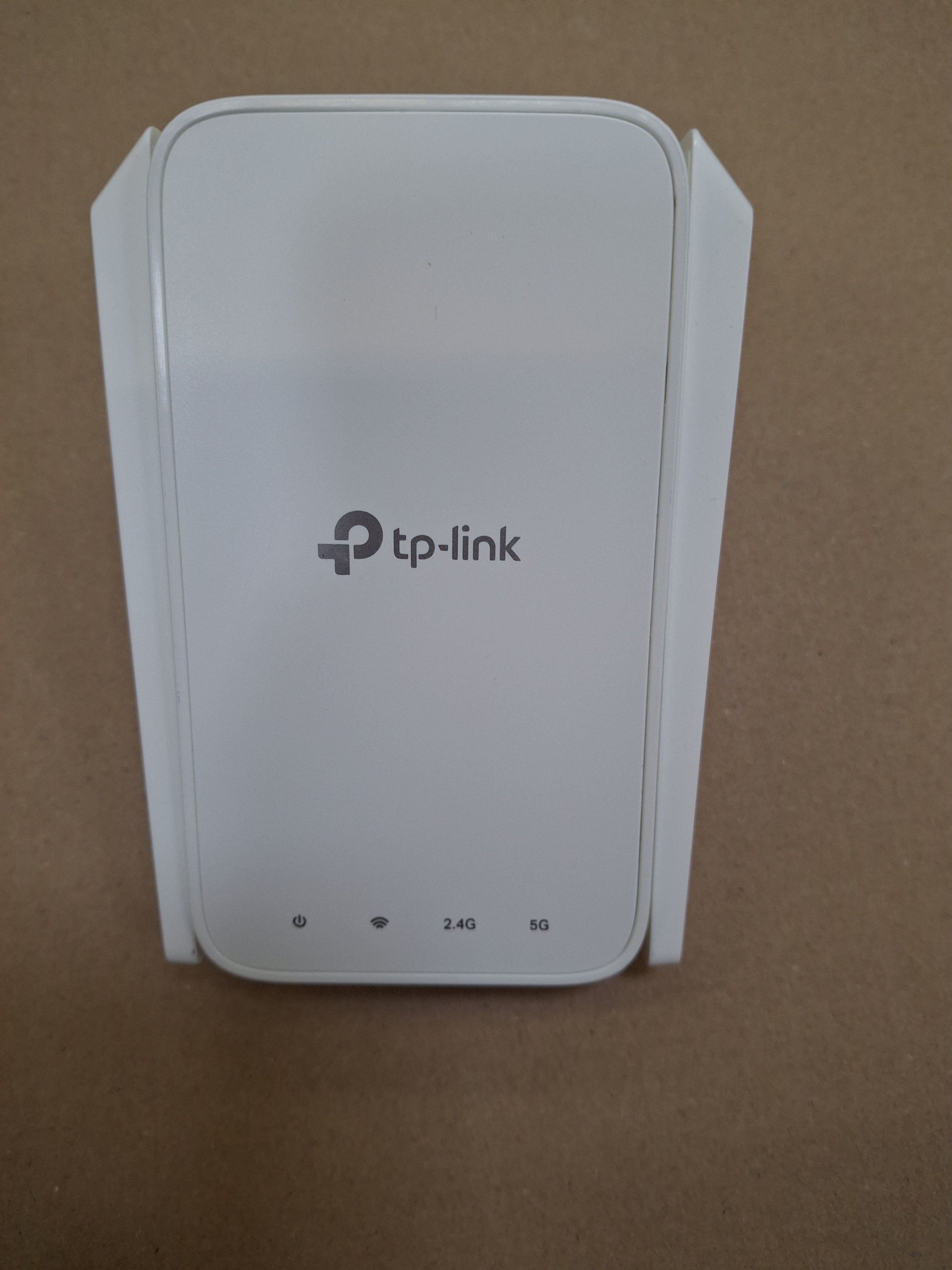 Biały przedłużacz Wi-Fi Mesh tp-link. Ma dwie anteny i trzy kontrolki.