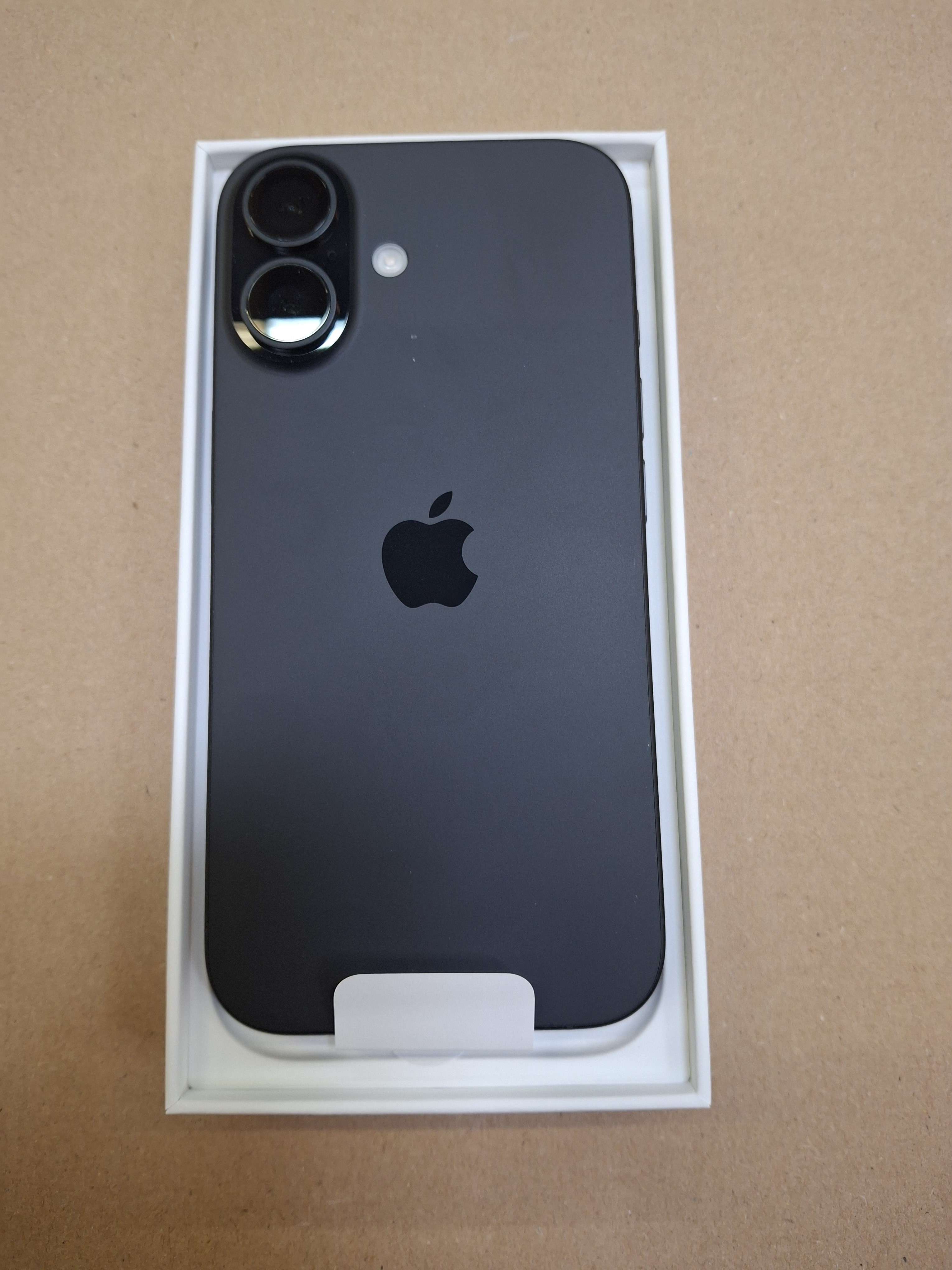 Czarny telefon w pudełku. Pokazano tył z aparatami i logo Apple.