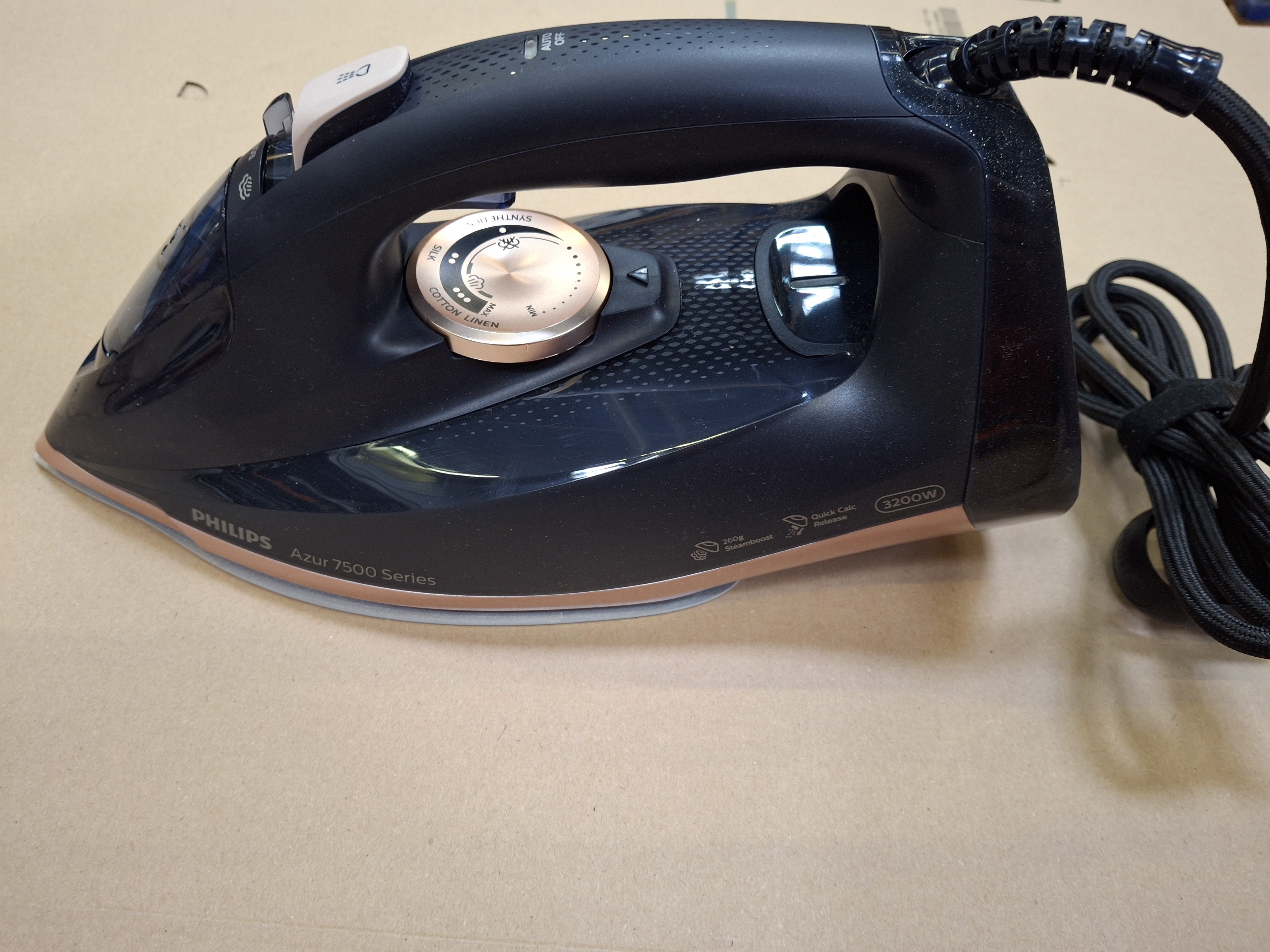 Zbliżenie czarnego żelazka Philips Azur serii 7500 na powierzchni.