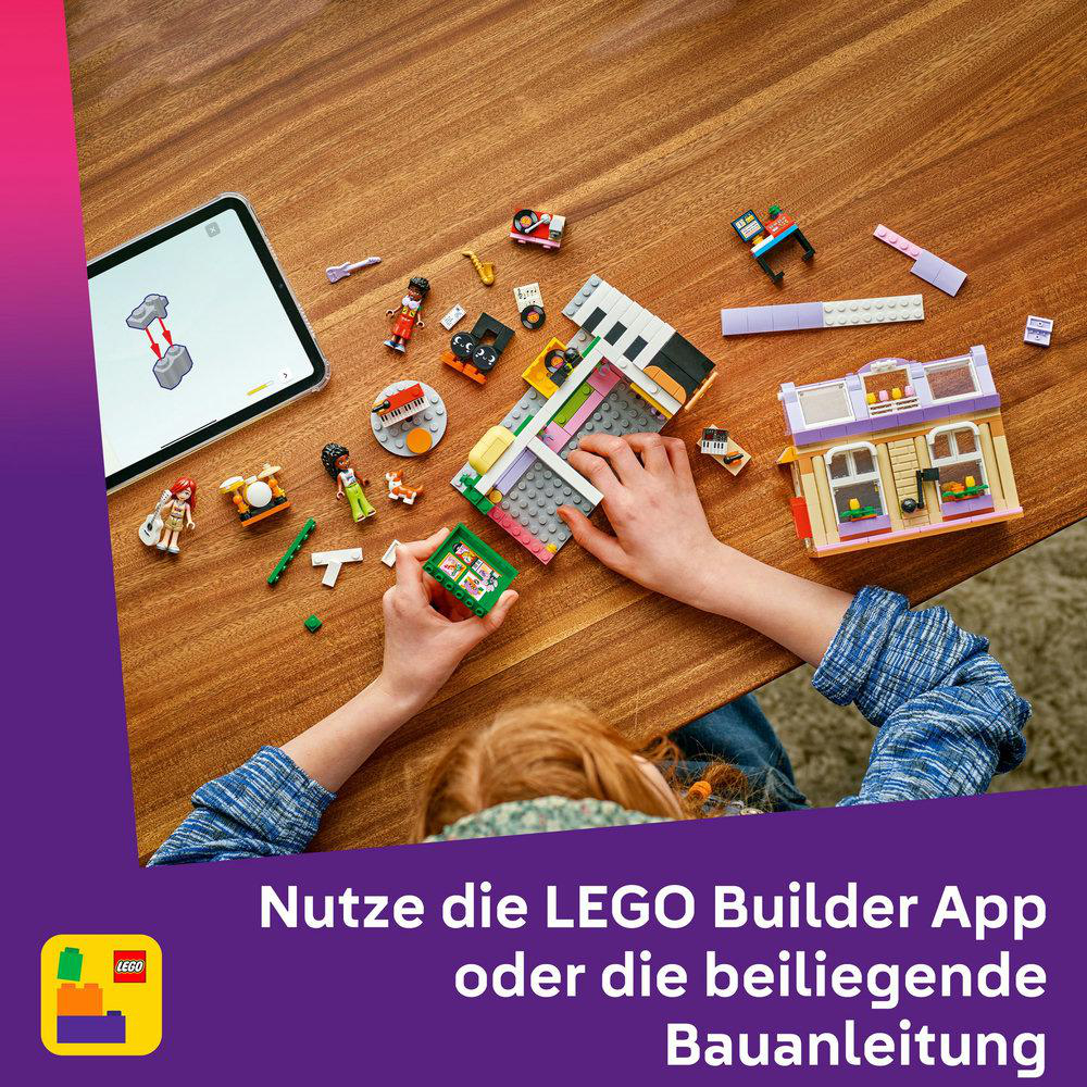Person spielt mit Lego Friends Set. Ein Tablet mit der Lego App befindet sich links. Verschiedene Lego-Teile verstreut.