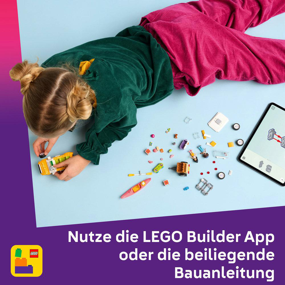 Ein Mädchen mit einem Lego-Set und einem Tablet. Verschiedene Lego-Teile sind verstreut. Das Mädchen baut Lego.
