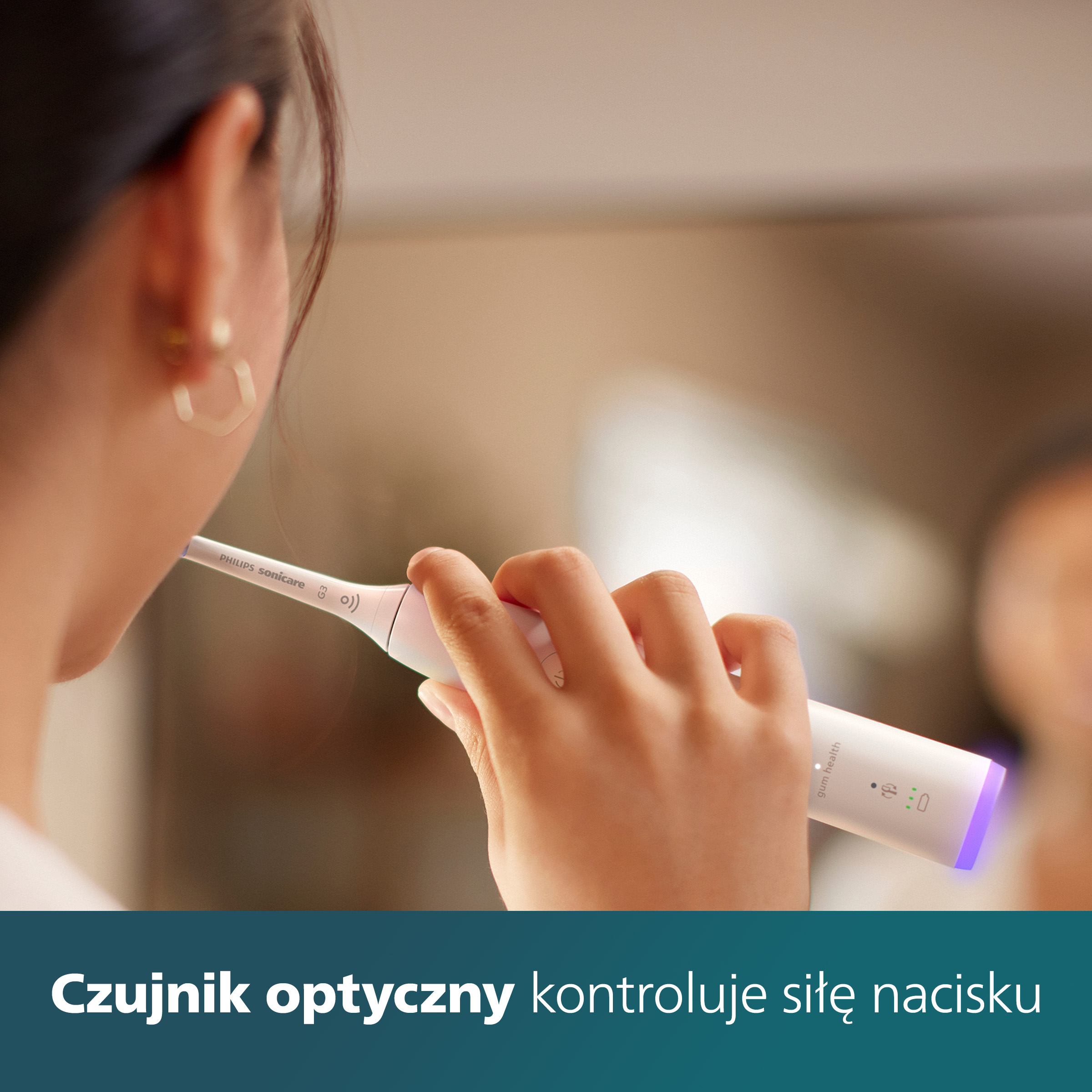 Kobieta myjąca zęby, czujnik optyczny kontroluje nacisk.