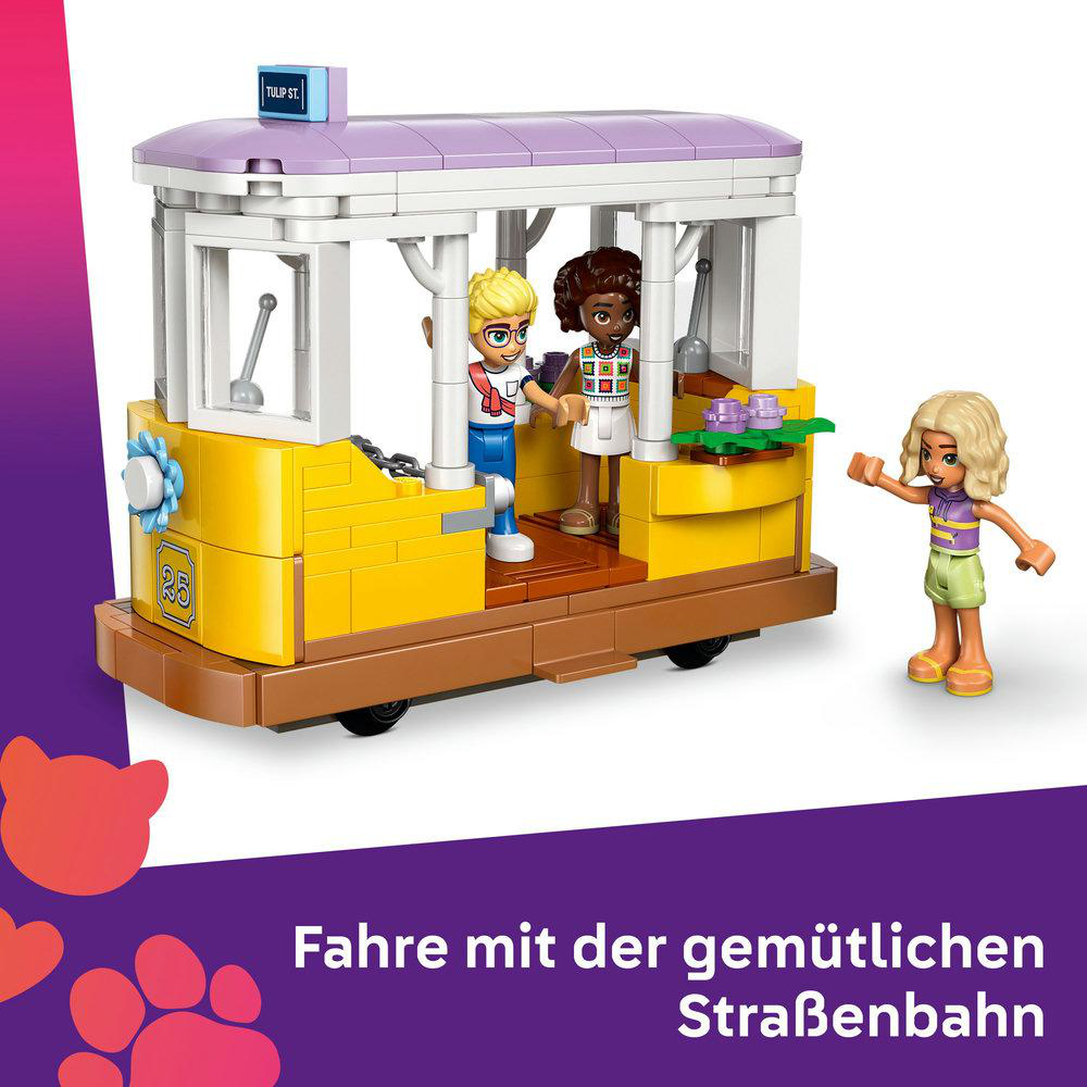 Eine gelbe Straßenbahn mit zwei Figuren. Ein Mädchen steht daneben.