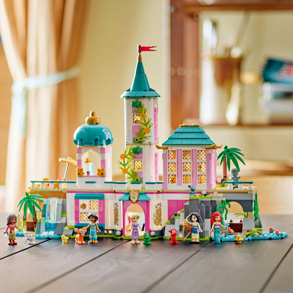 Zusammengebautes Disney Prinzessinnen Schloss LEGO Set mit Figuren. Auf einem Holztisch mit mehreren Charakteren.