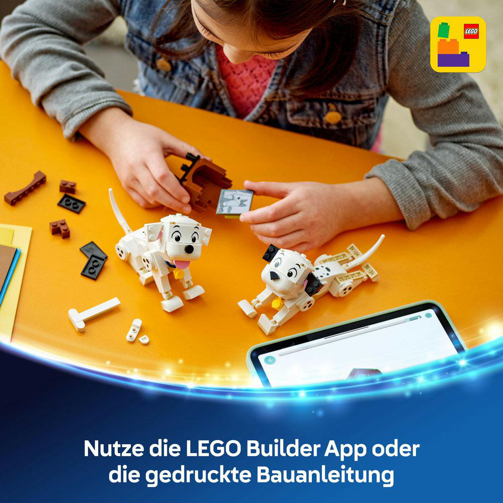 Mädchen spielt mit einem 101 Dalmatiner LEGO Set, neben zwei Dalmatiner-Welpen und Bausteinen.