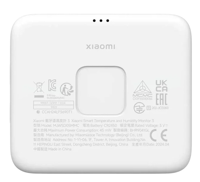 Tył białego kwadratowego urządzenia. Ma logo, informacje prawne i mały przycisk resetowania.