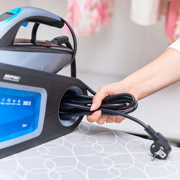 Osoba trzyma czarny kabel zasilający żelazka.