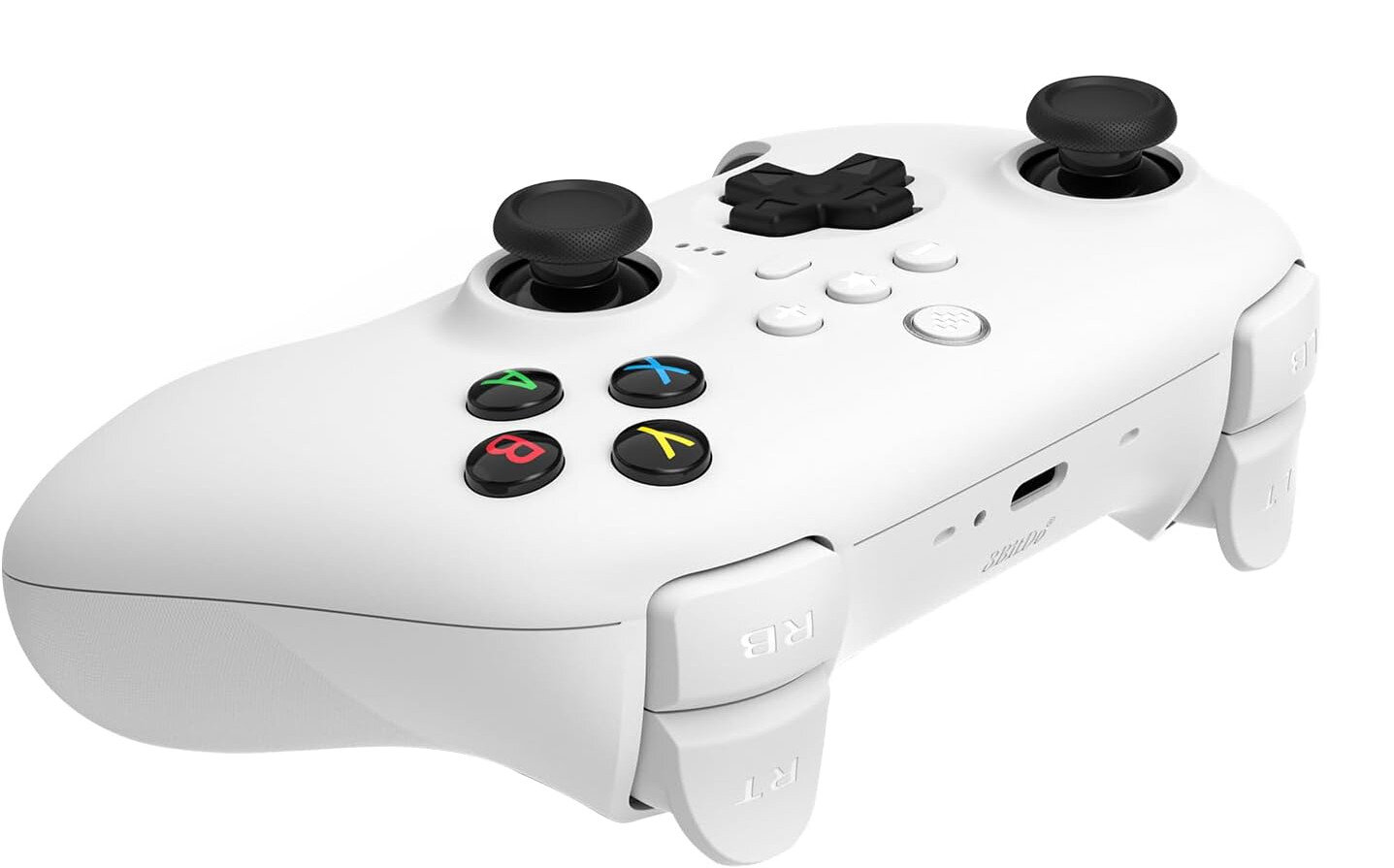 Biały kontroler do gier z czarnymi joystickami i przyciskami. Kolorowe przyciski to A, B, X, Y. Białe tło.