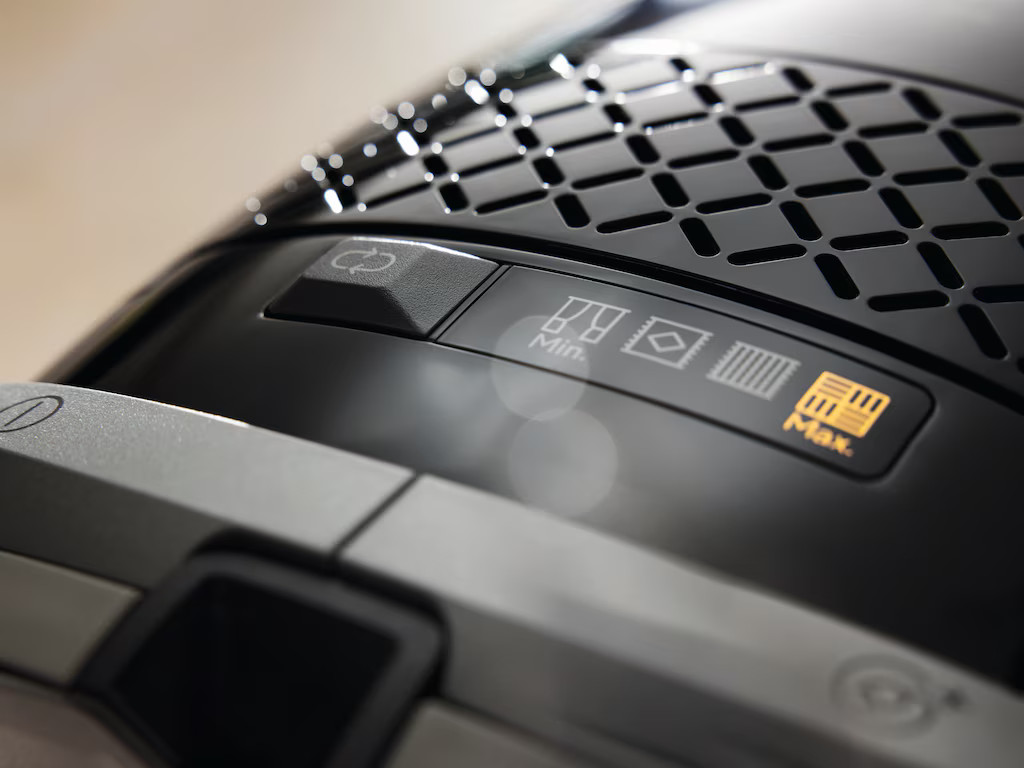 Zbliżenie panelu sterowania odkurzacza. Ma przyciski i kontrolki.