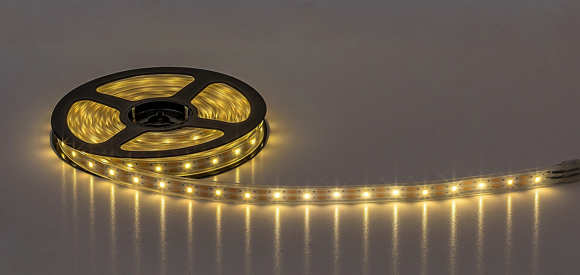 LED szalag orsón. A LED-ek világítanak. Világos háttér.