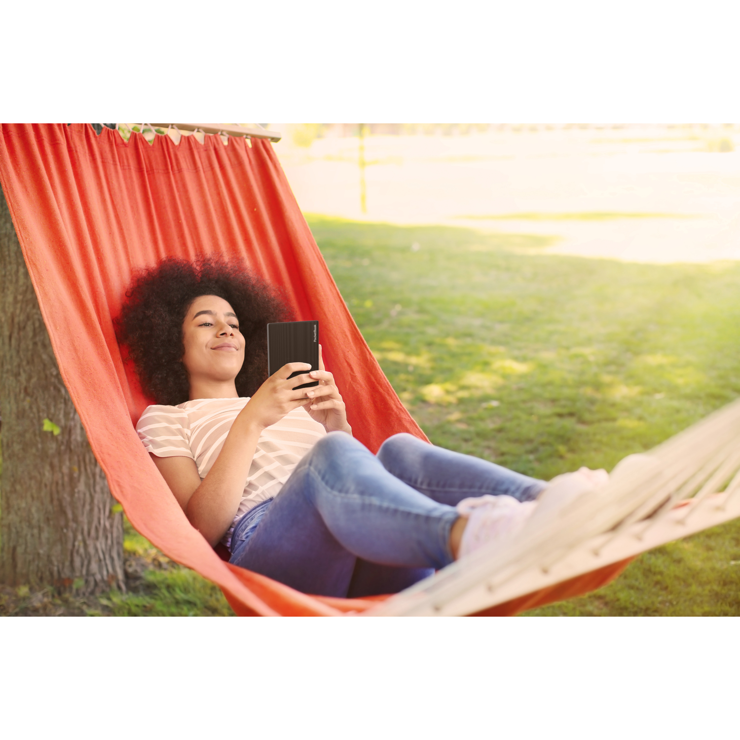 Een jonge vrouw in een hangmat leest een e-reader. De e-reader toont een getextureerde achterkant.