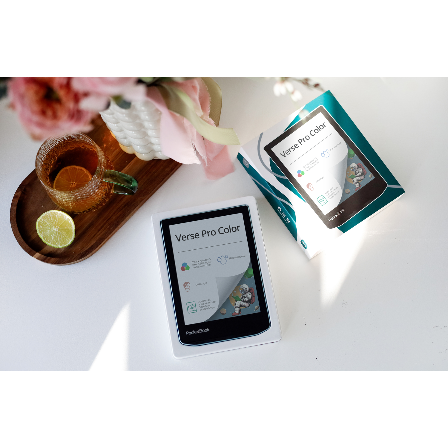 E-reader en doos op een witte tafel met thee en limoen. Toont Verse Pro Color info.