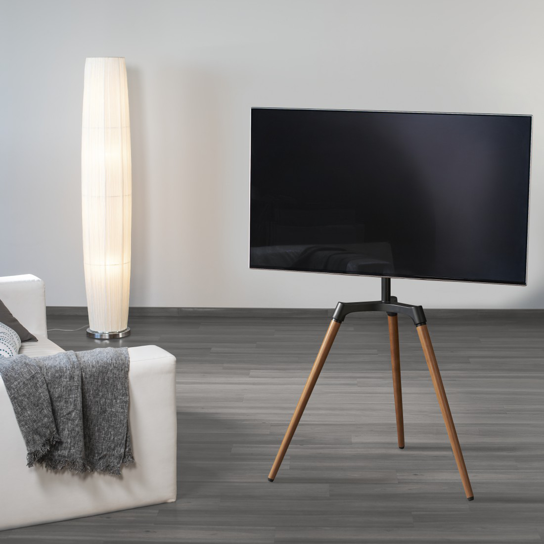 TV fekete és fa állványon egy szobában.