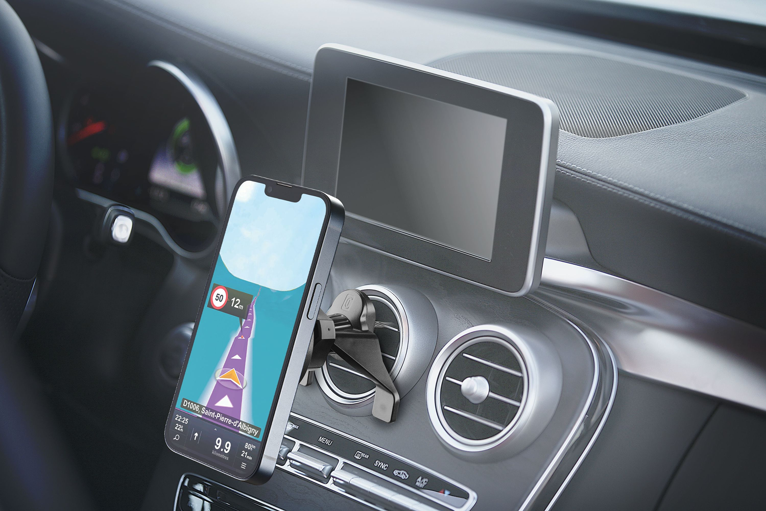 Interior de coche con teléfono montado en un soporte. El teléfono muestra una app de navegación con mapa de carretera.