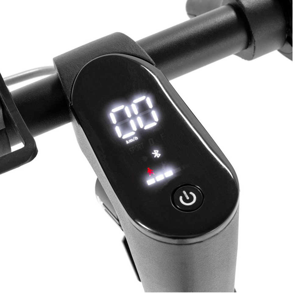 Zbliżenie cyfrowego wyświetlacza hulajnogi elektrycznej, pokazującego prędkość, baterię i przycisk zasilania.