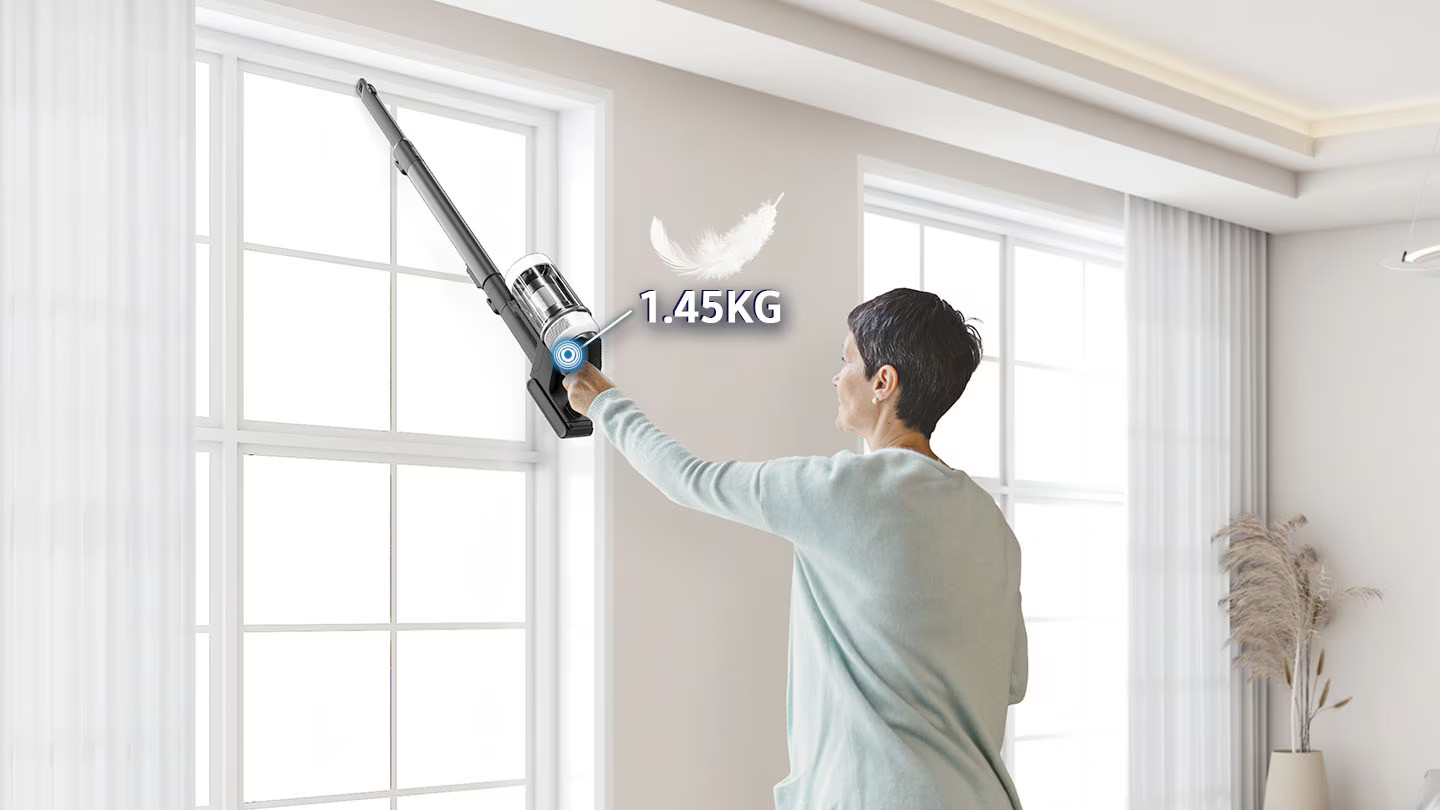 Kobieta używa odkurzacza Samsung do czyszczenia, podkreślając lekką wagę 1,45 KG.