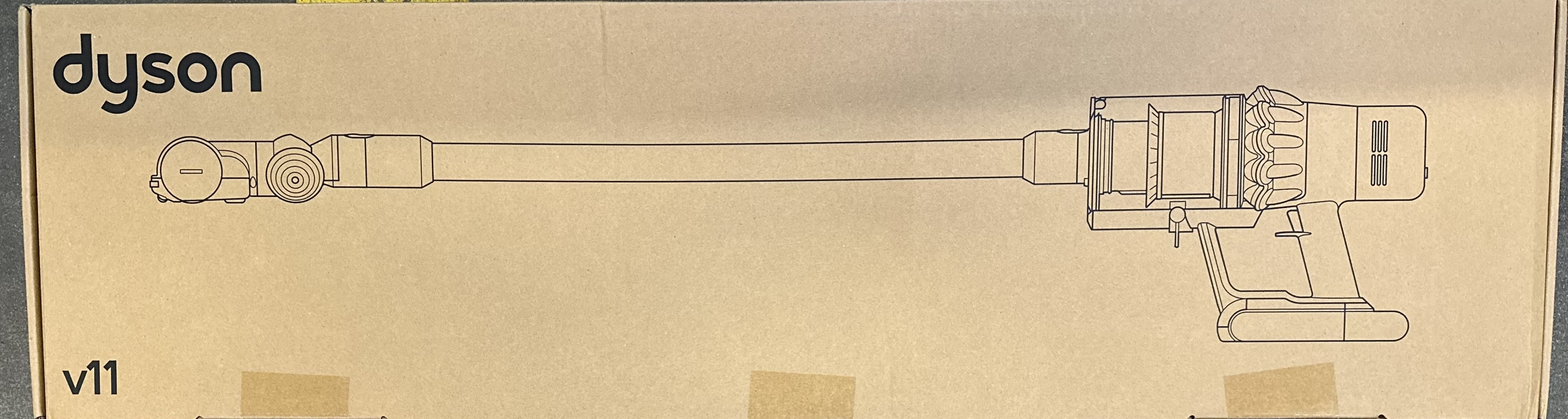 Kartonowe pudełko z rysunkiem odkurzacza Dyson.