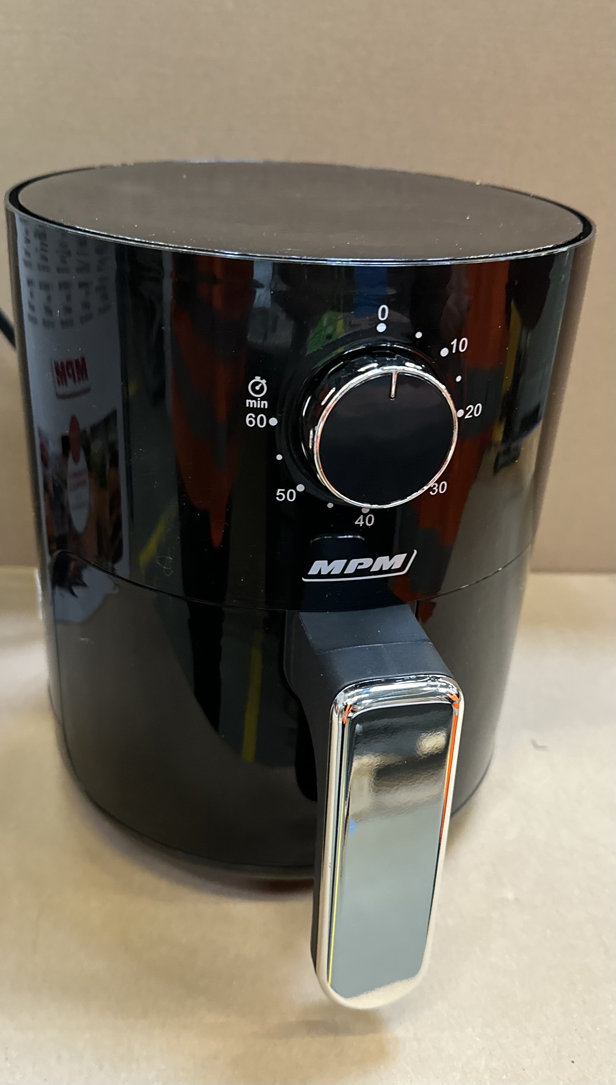 Czarna frytownica powietrzna z wyświetlaczem cyfrowym, uchwytem i pokrętłem timera ustawionym na 50 minut.