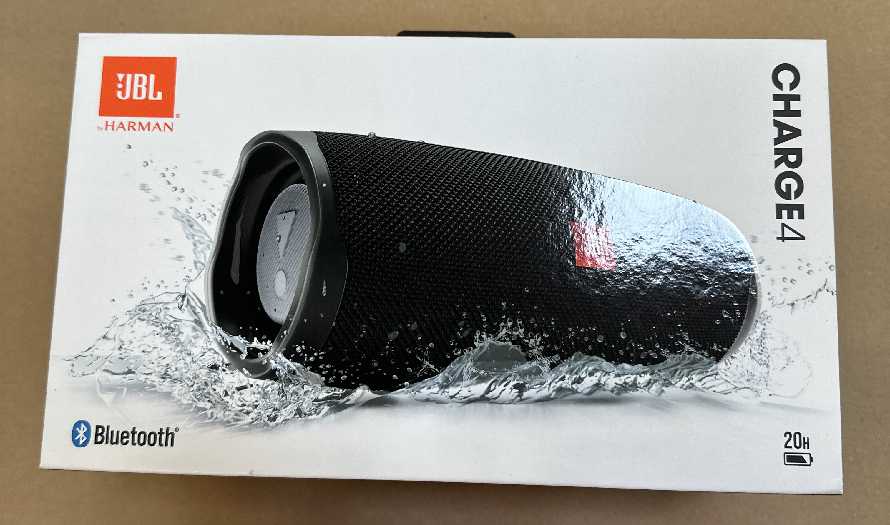 Pudełko głośnika JBL Charge 4 z głośnikiem i rozpryskami wody.