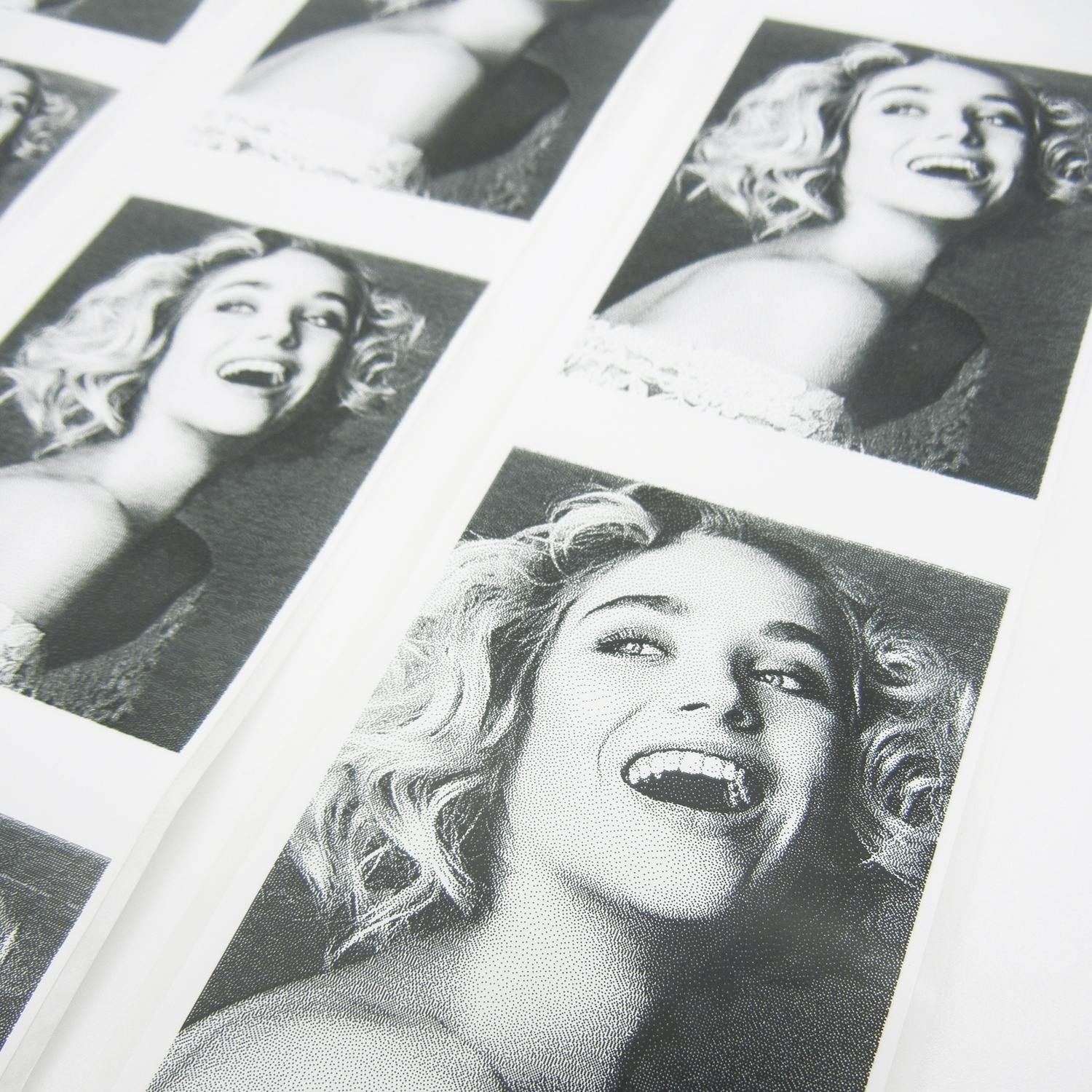 Primo piano di più strisce fotografiche in bianco e nero. Ritratto di donna sorridente su ciascuna. Sfondo bianco.
