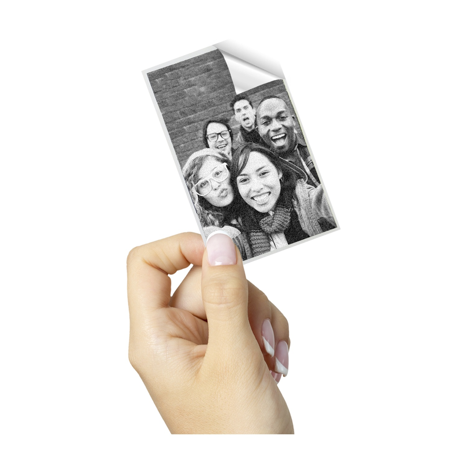 Mano che tiene un adesivo con una foto di gruppo. Persone sorridenti. Lo sfondo è un muro di mattoni.