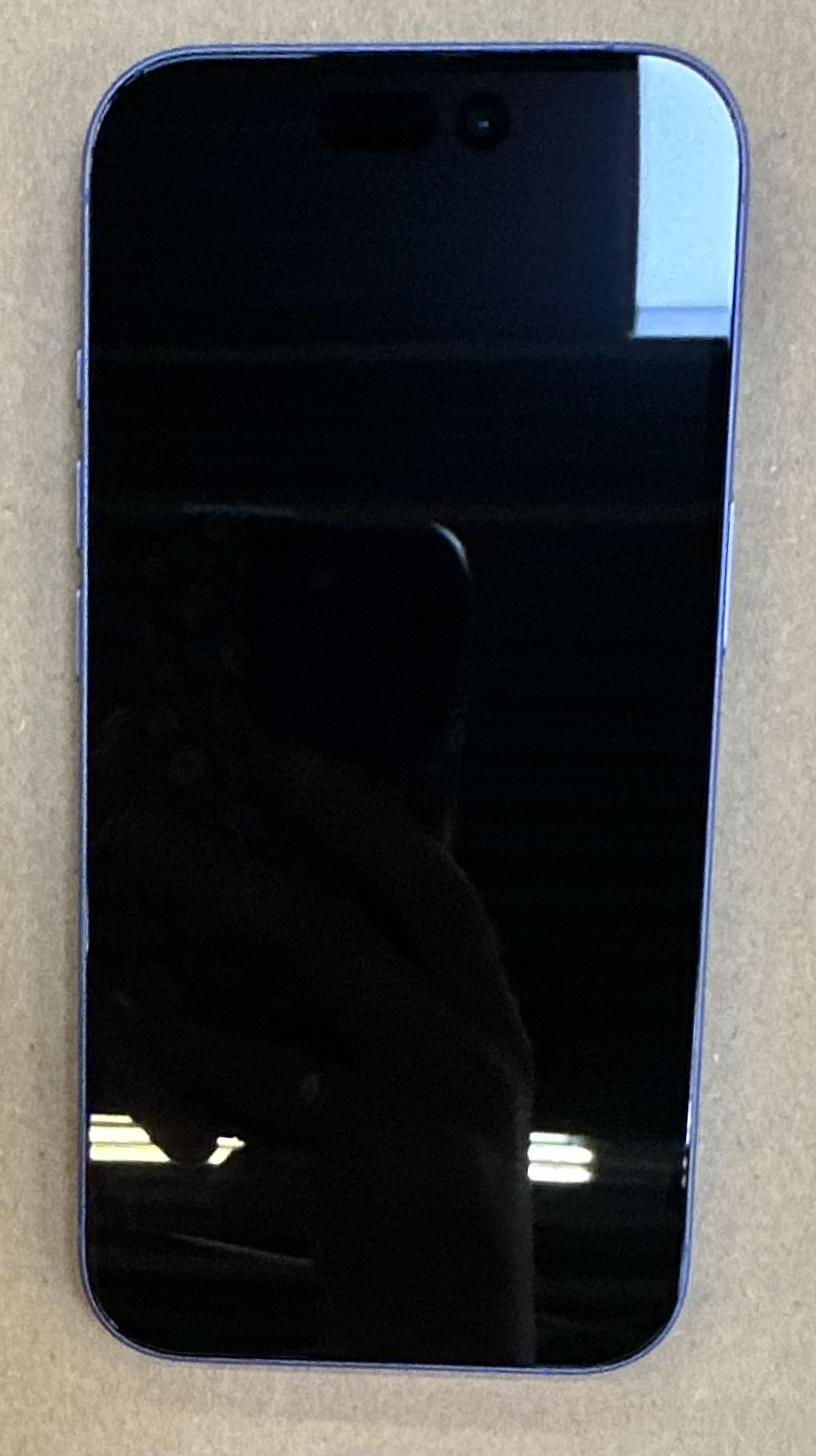 iPhone 14 Pro, niebieski, widok z tyłu, pokazujący moduł aparatu i odbicie ekranu.
