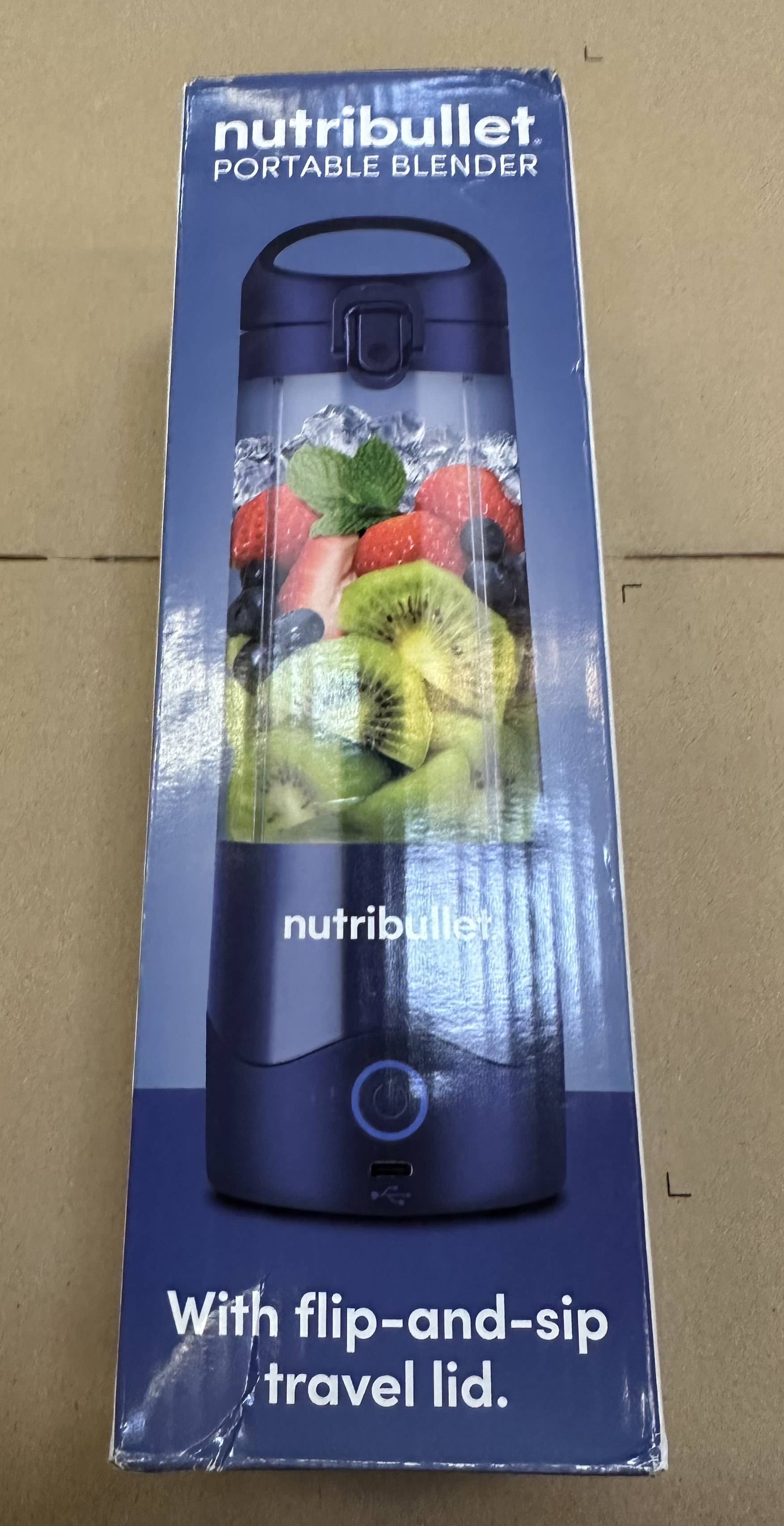 Pudełko blendera Nutribullet. Obraz blendera z owocami i lodem. Niebieskie pudełko.