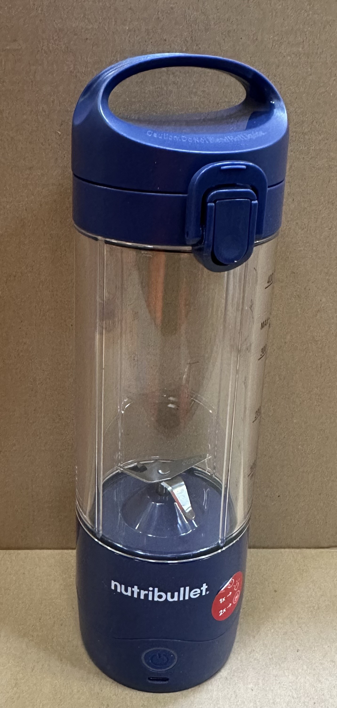 Blender Nutribullet. Niebieska podstawa i pokrywa, przezroczysty pojemnik. Widoczne ostrza.