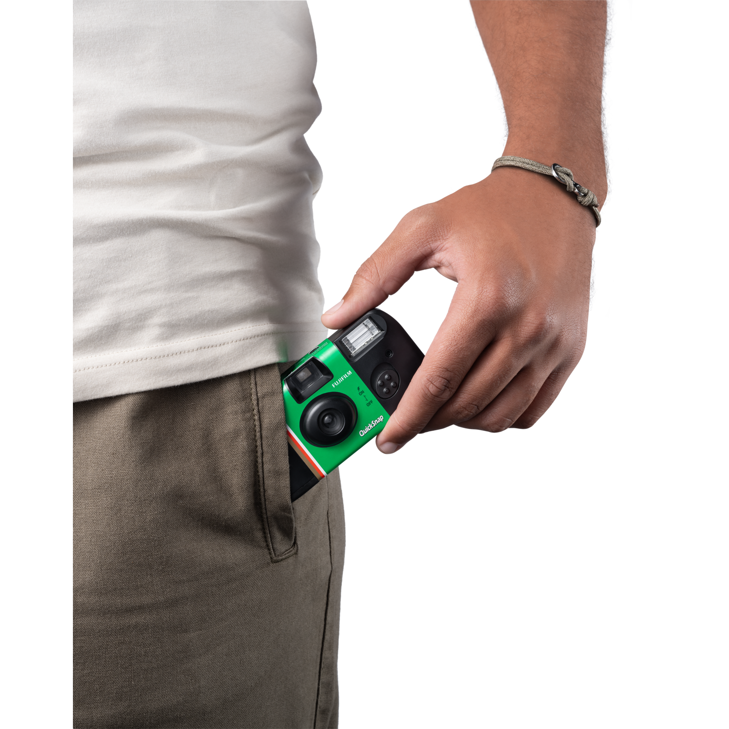 Main d'une personne tenant un appareil photo QuickSnap vert dans sa poche.
