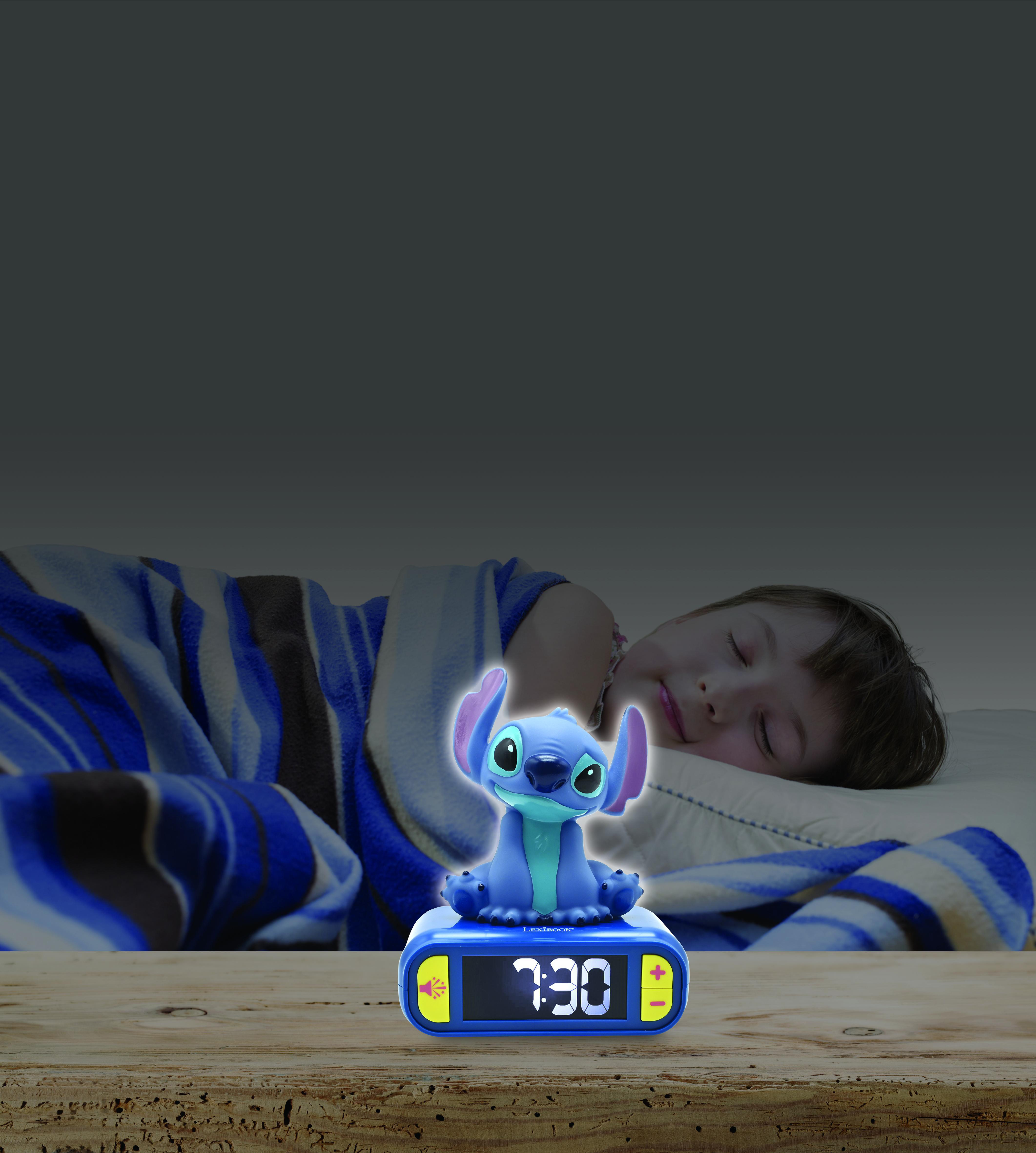Ein Kind schläft neben einem Stitch-Wecker, die Uhrzeit ist 7:30. In der Nähe befindet sich eine blaue und gestreifte Decke.