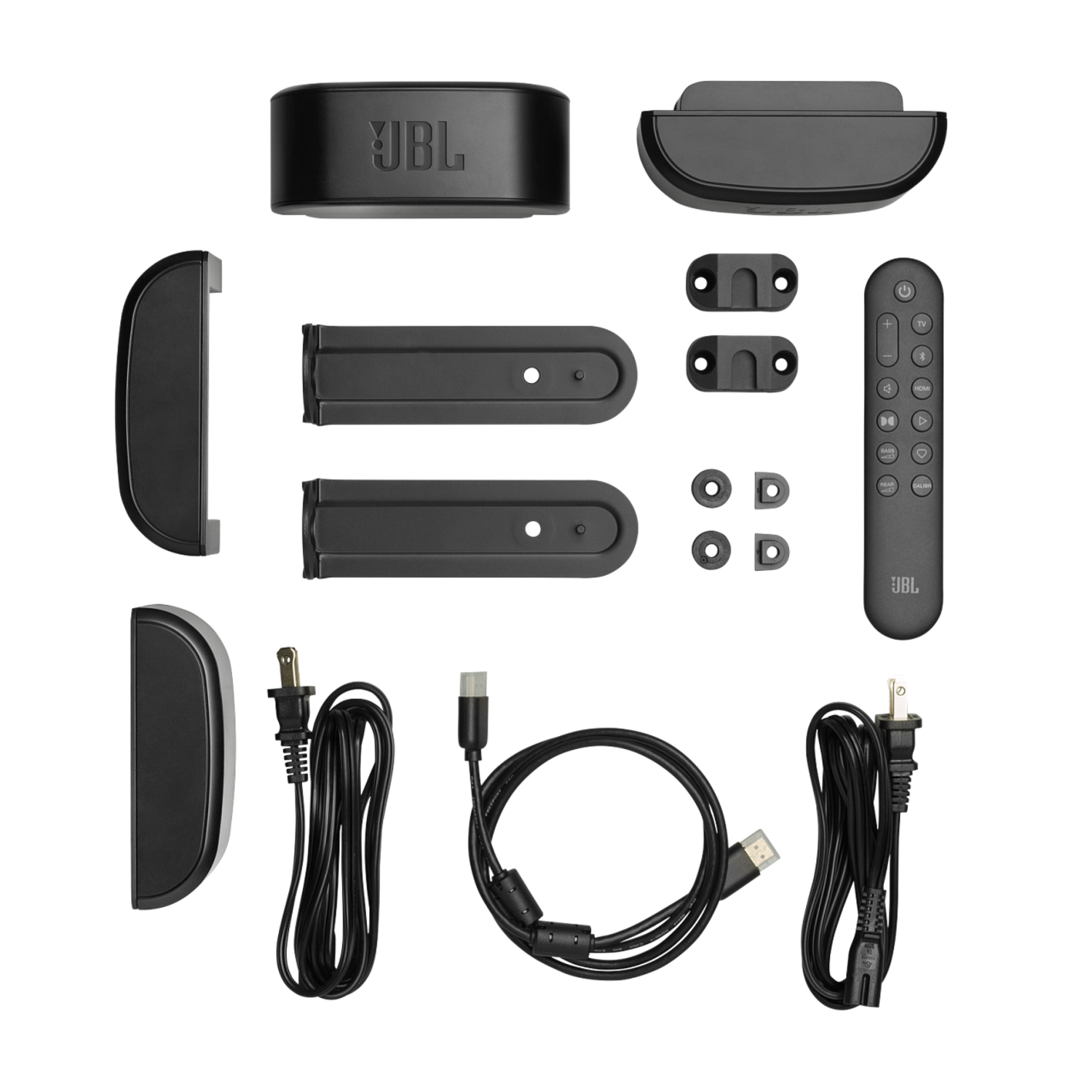 Plusieurs composants et accessoires de barre de son JBL noirs sur une surface sombre.