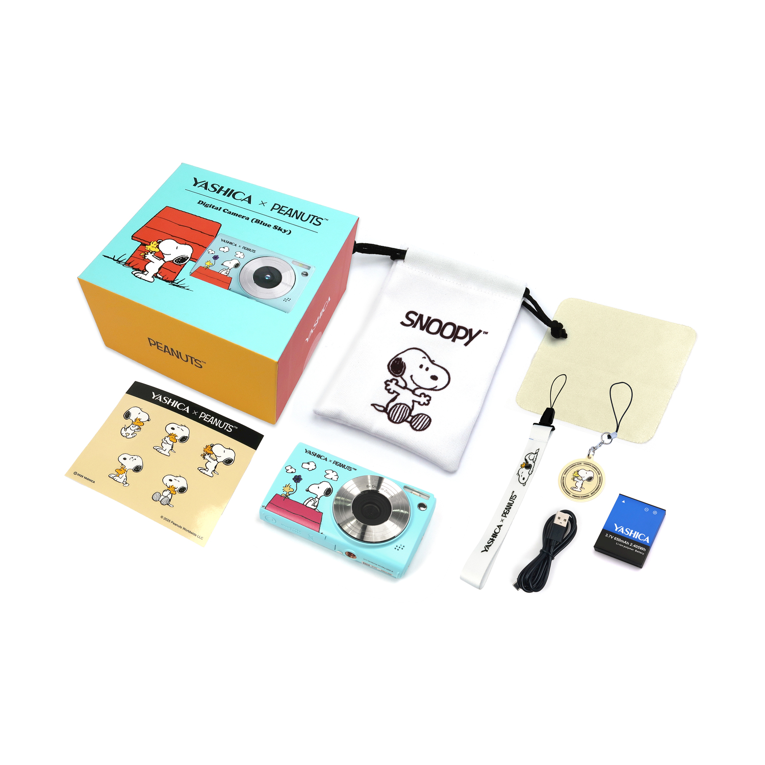 Fotocamera e accessori in una scatola. Include borsa Snoopy, cinturino e panno per la pulizia. Sfondo bianco.