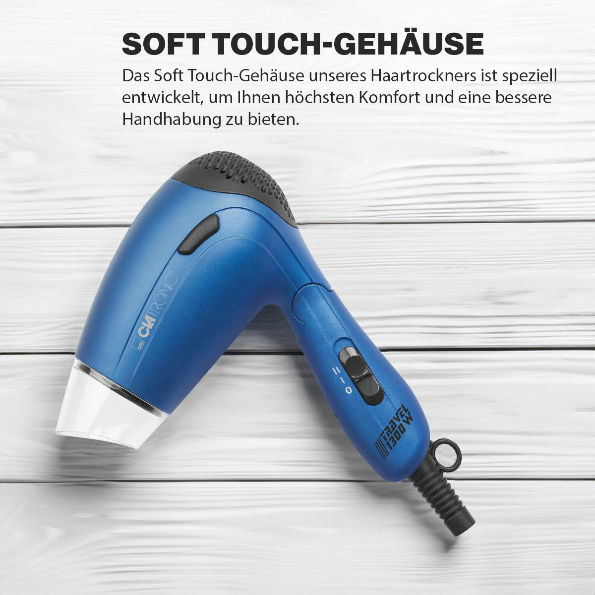 Ein blauer Fön auf einer Holzoberfläche. Der Text 'Soft Touch-Gehäuse' ist sichtbar.