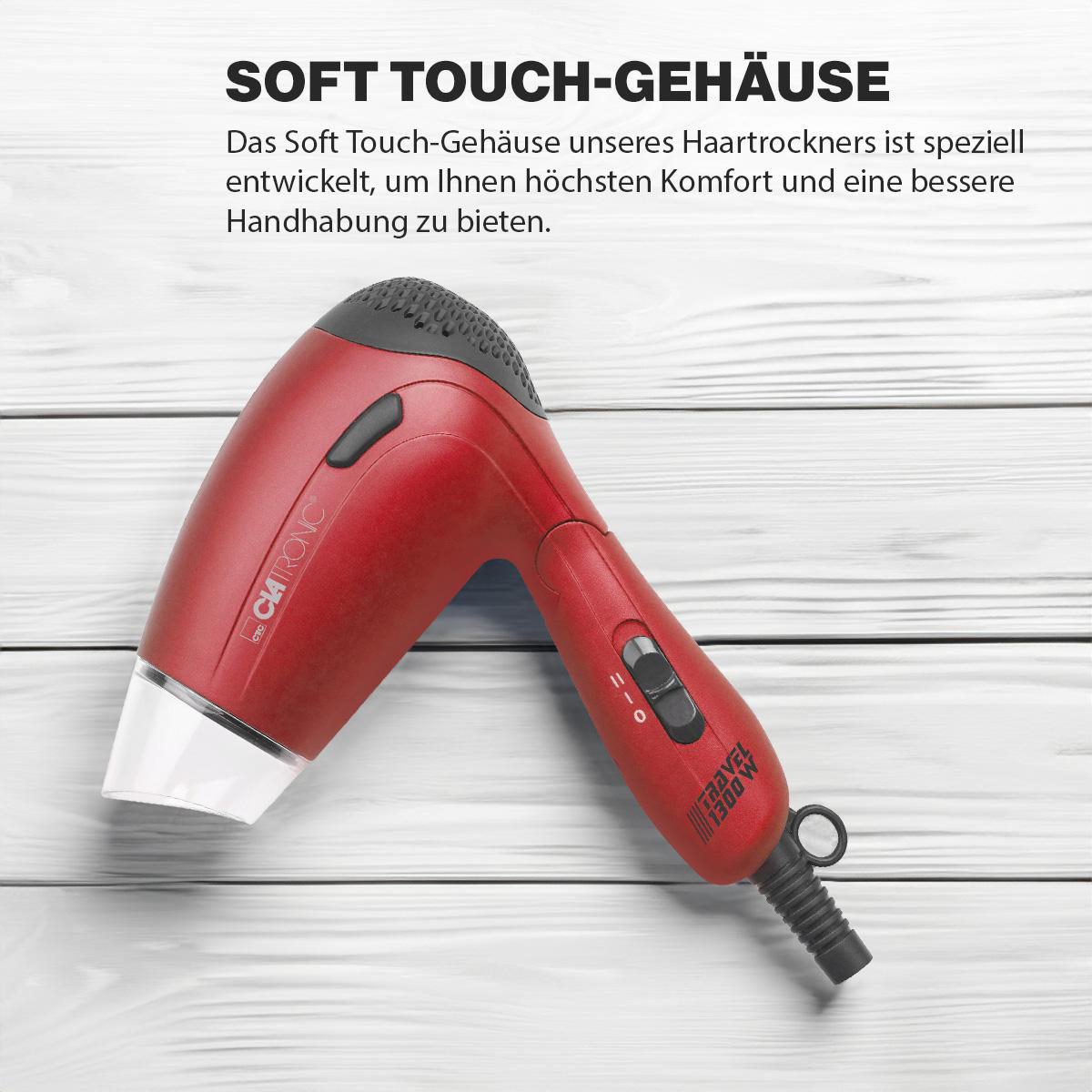 Ein roter Fön auf einer Holzoberfläche. Der Text 'Soft Touch-Gehäuse' ist sichtbar.