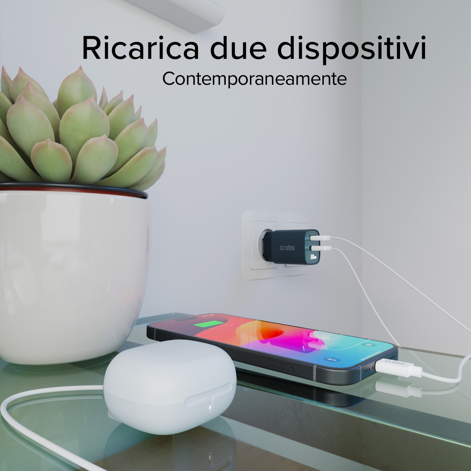Un caricatore in una presa a muro che carica un telefono e auricolari. Sono visibili anche una pianta e un tavolo di vetro.
