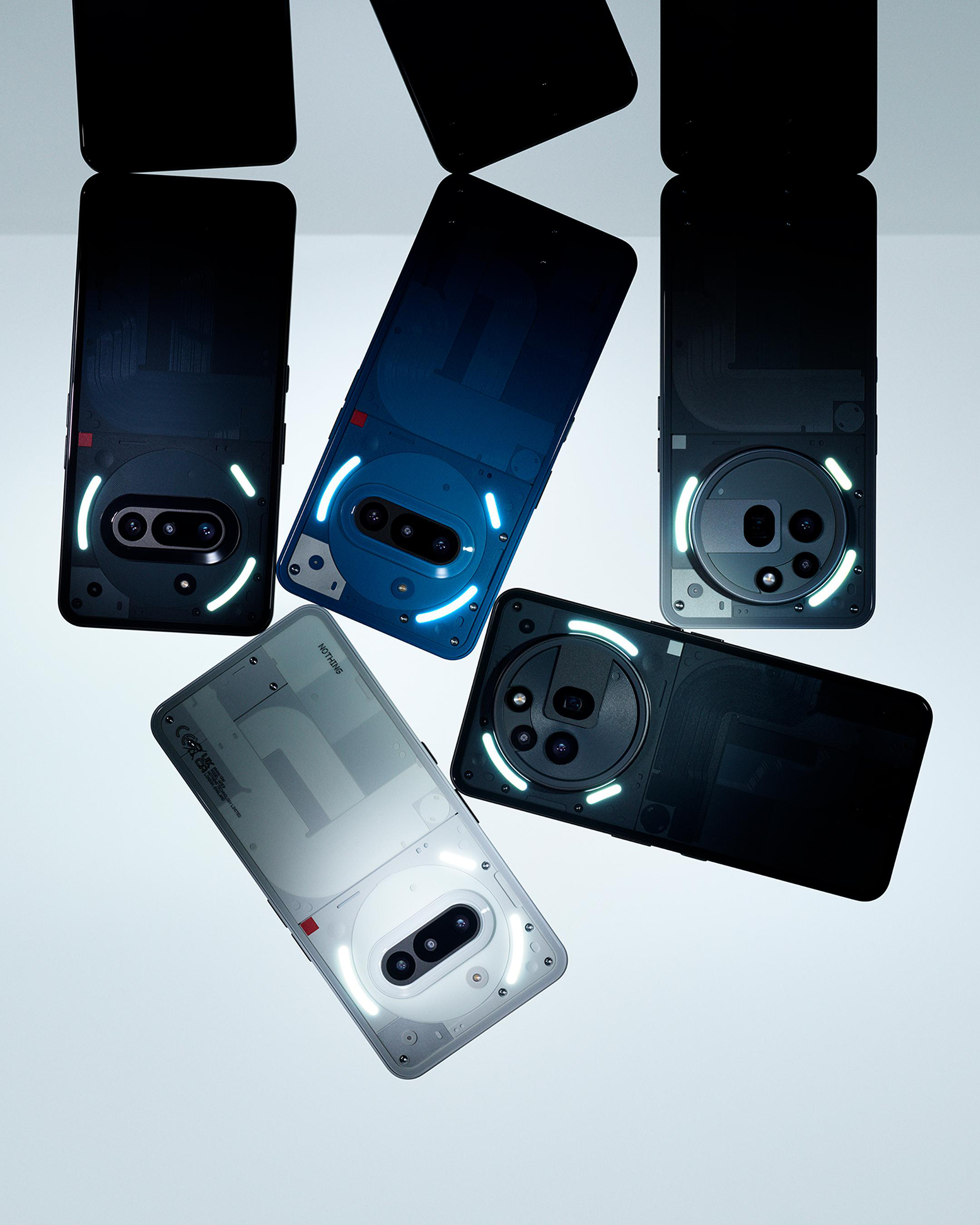 Mehrere Telefone mit ihren Rückseiten nach oben, zeigen Kameras und Lichter. Weißer Hintergrund.