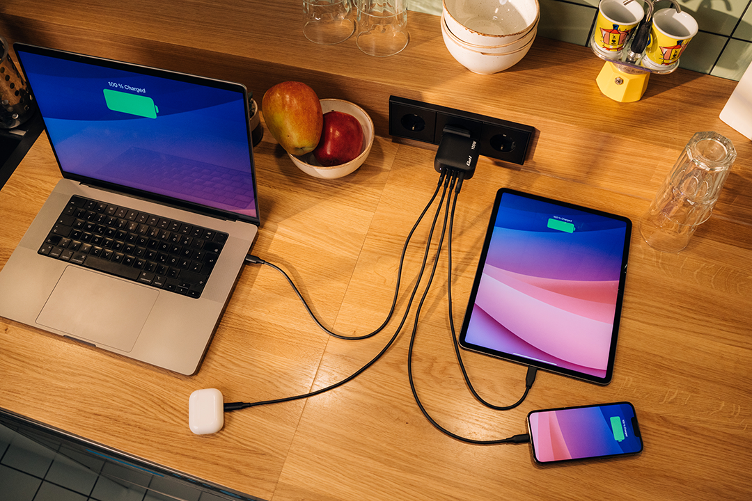 Laptop, tablet, telefon töltése faasztalon töltővel és étellel.